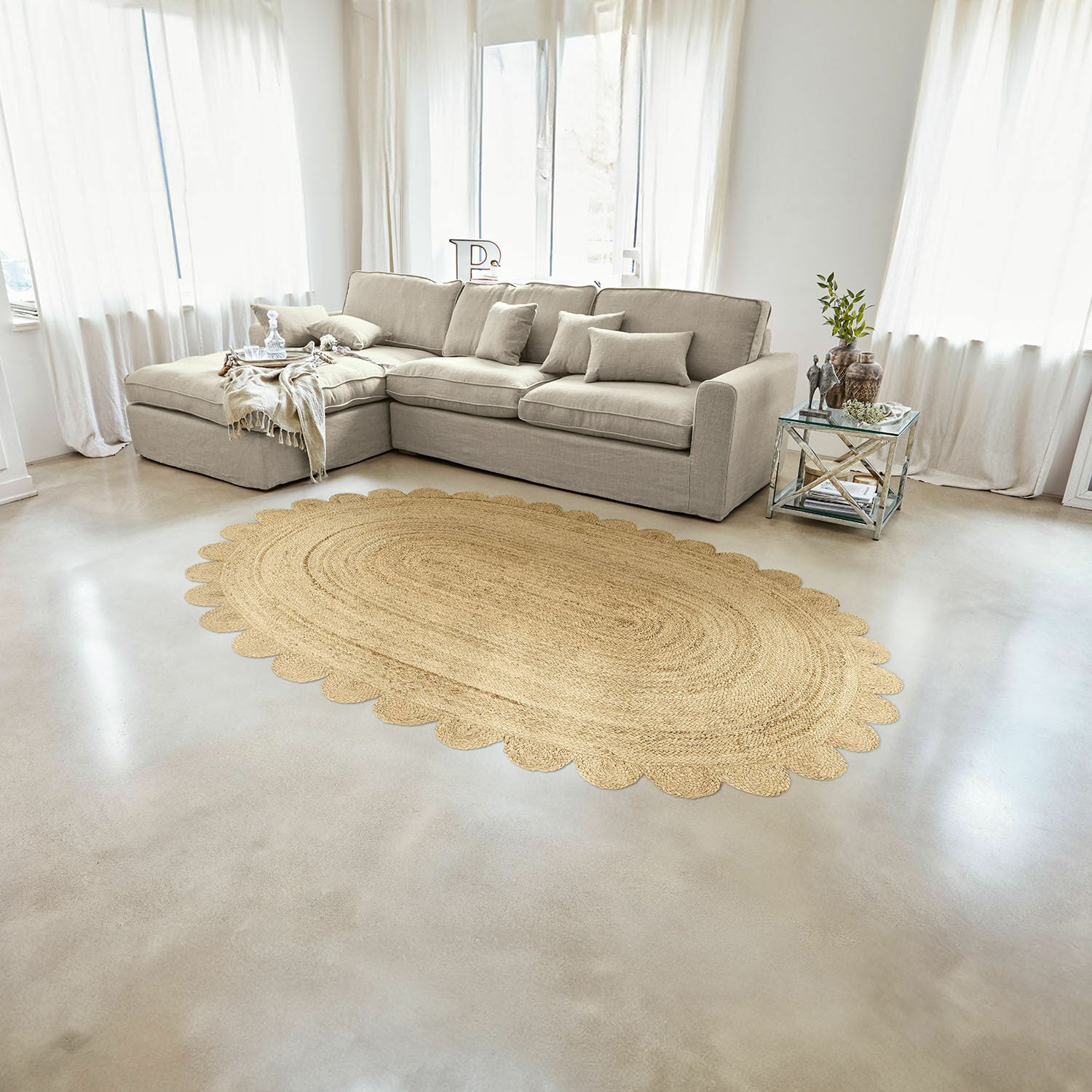 Alfombra Ferce Alfombra ovalada de yute color natural con borde festoneado en sala luminosa con sofá beige