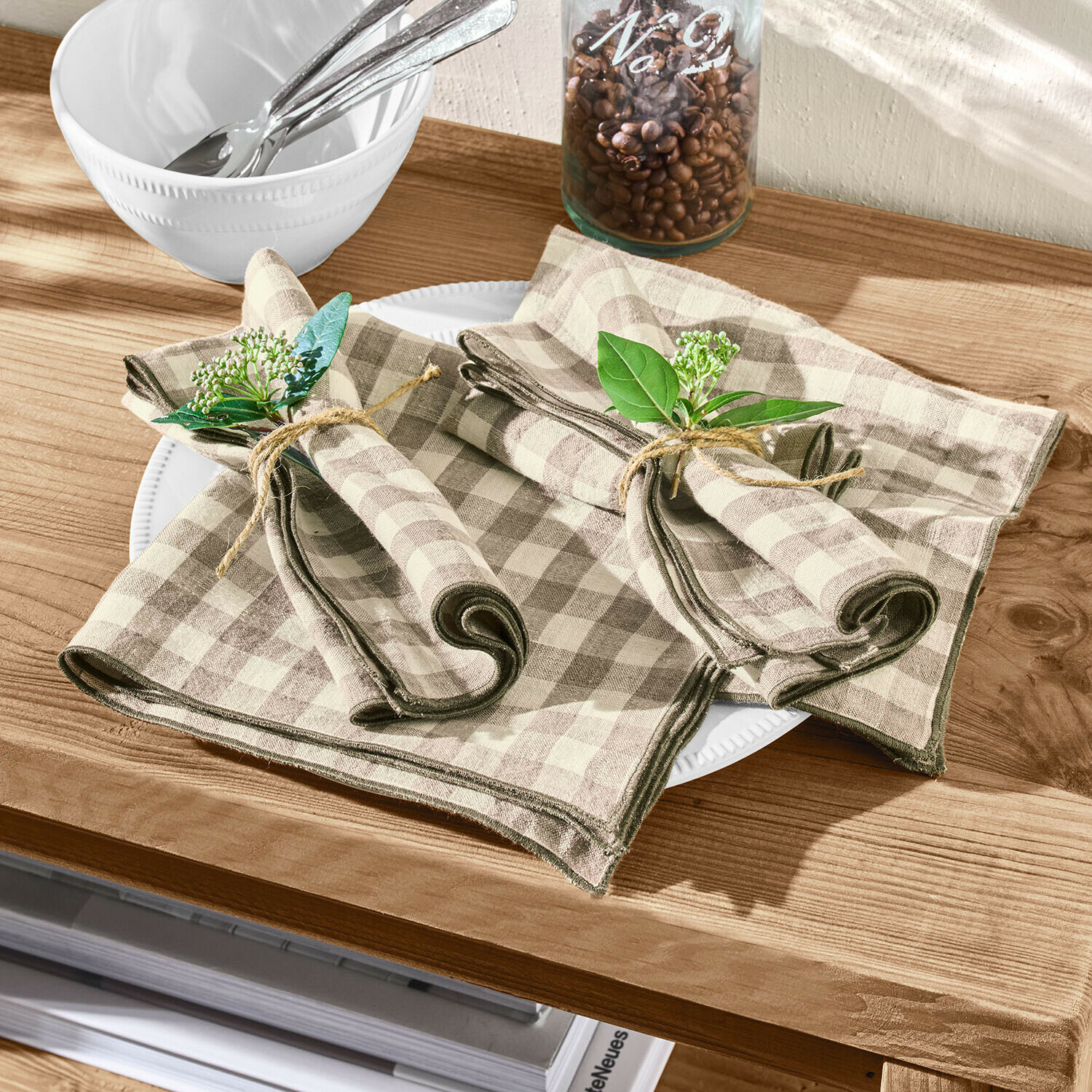 Set de 4 servilletas Marrowby Servilletas de lino beige con cuadros marrones y ramas verdes decorativas sobre mesa de madera
