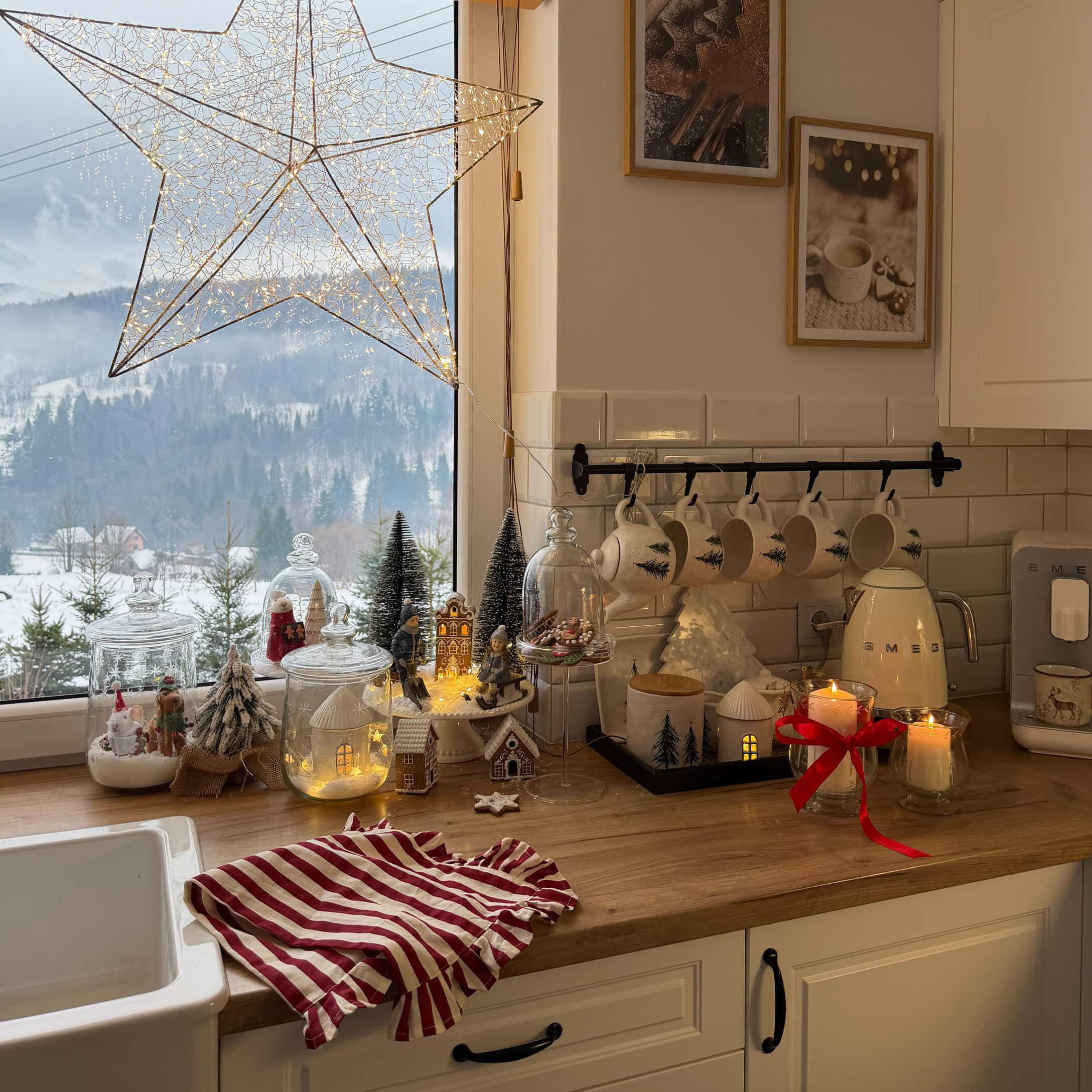 Cocina con encimera de madera decorada para Navidad, tazas blancas con diseño de árbol y luces LED
