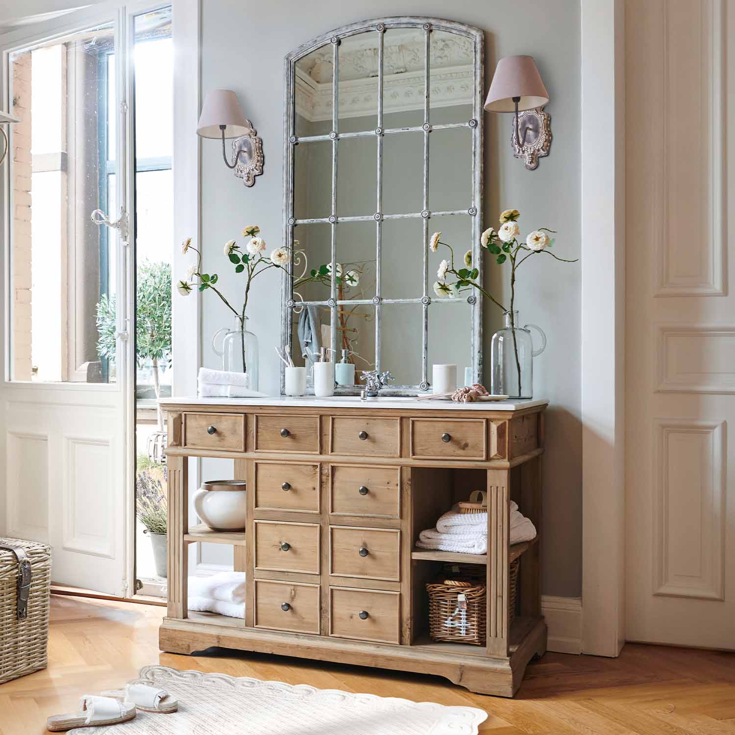 Cómoda de madera natural con múltiples cajones y espejo vintage grande en tono claro