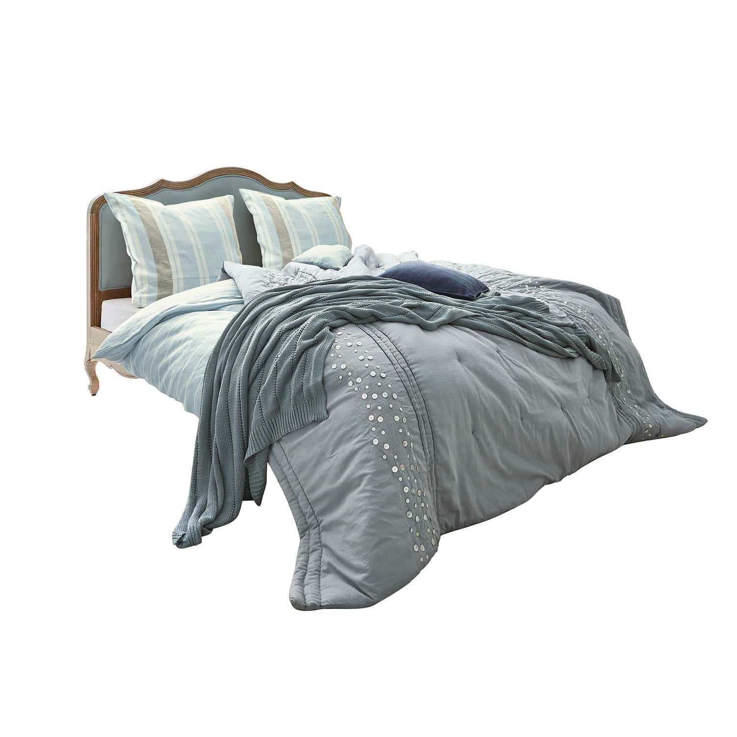 Cama Serravalle Cama con cabecero de madera y ropa de cama azul con cojines decorativos y manta tejida