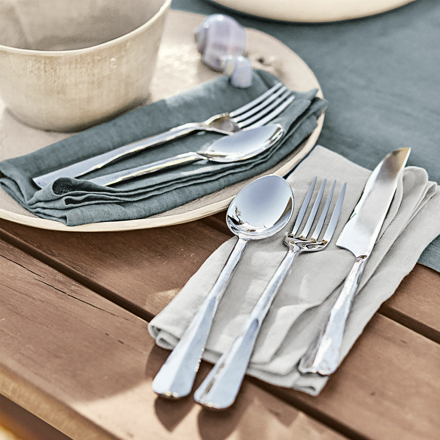 Cubiertos Malden Juego de cubiertos de acero inoxidable plateados sobre servilletas de lino en mesa de madera
