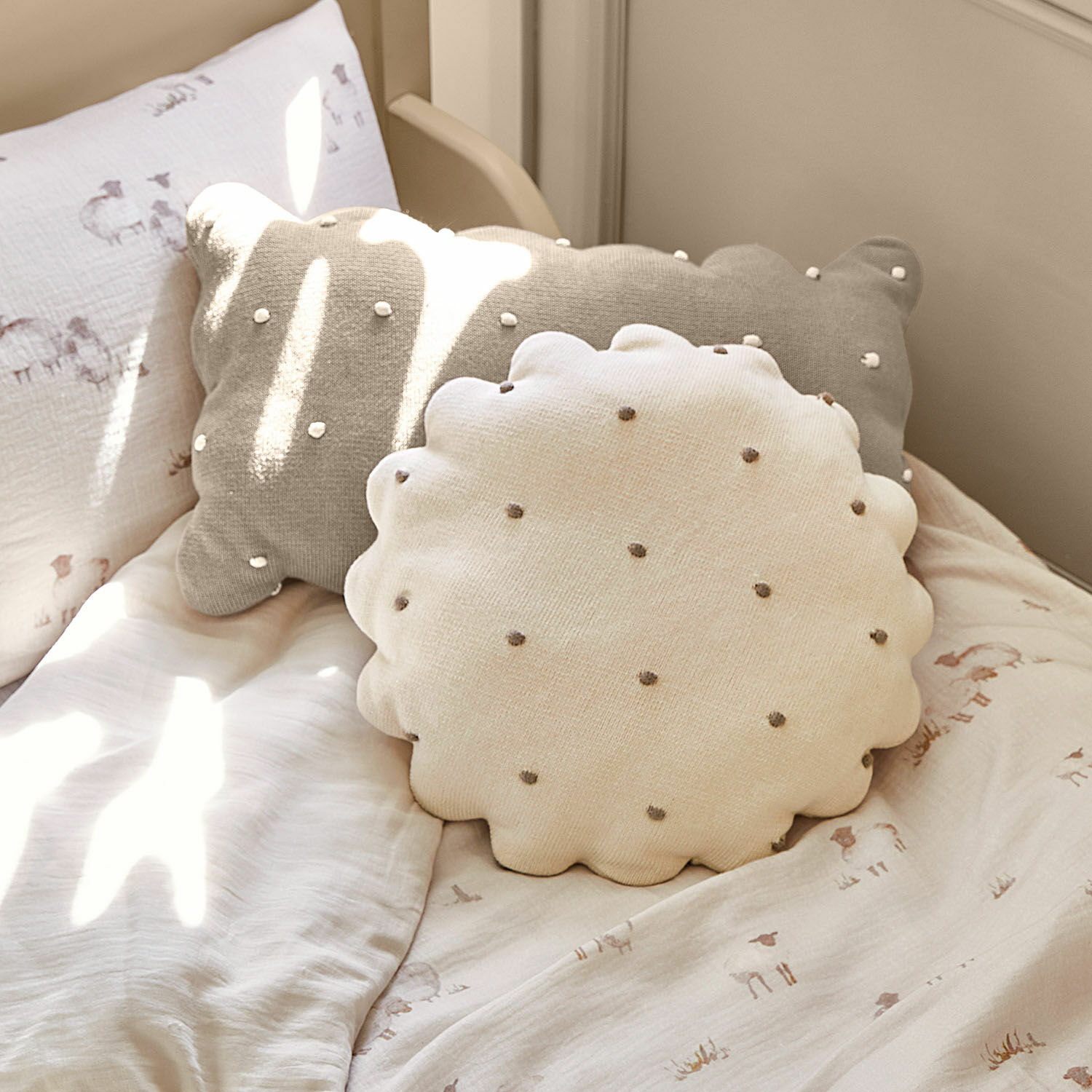 Set de 2 cojines Saphie Cojines decorativos redondo y rectangular de algodón en beige y gris sobre cama clara