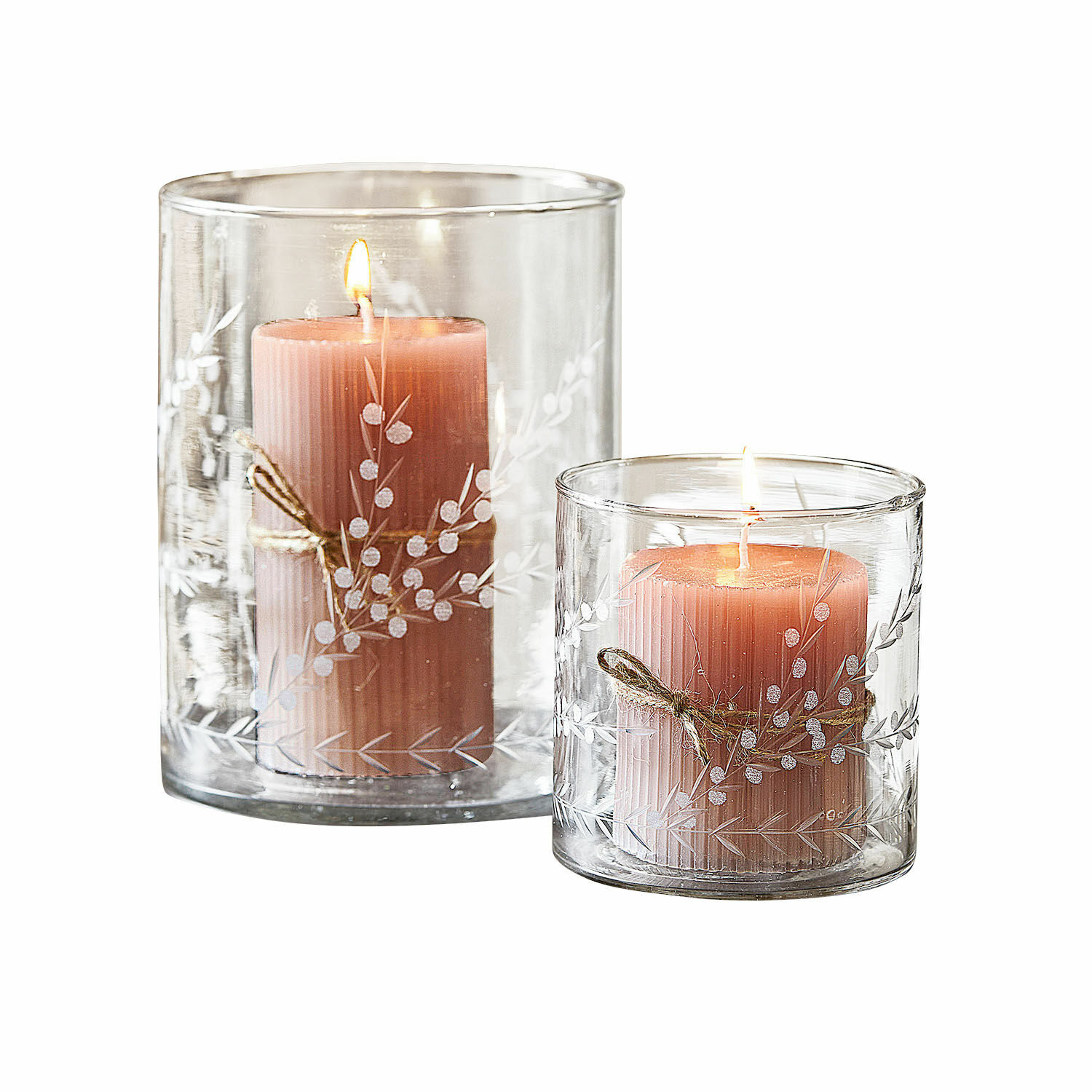 Dos velas rosas en portavelas de vidrio transparente con diseño decorativo y cuerda