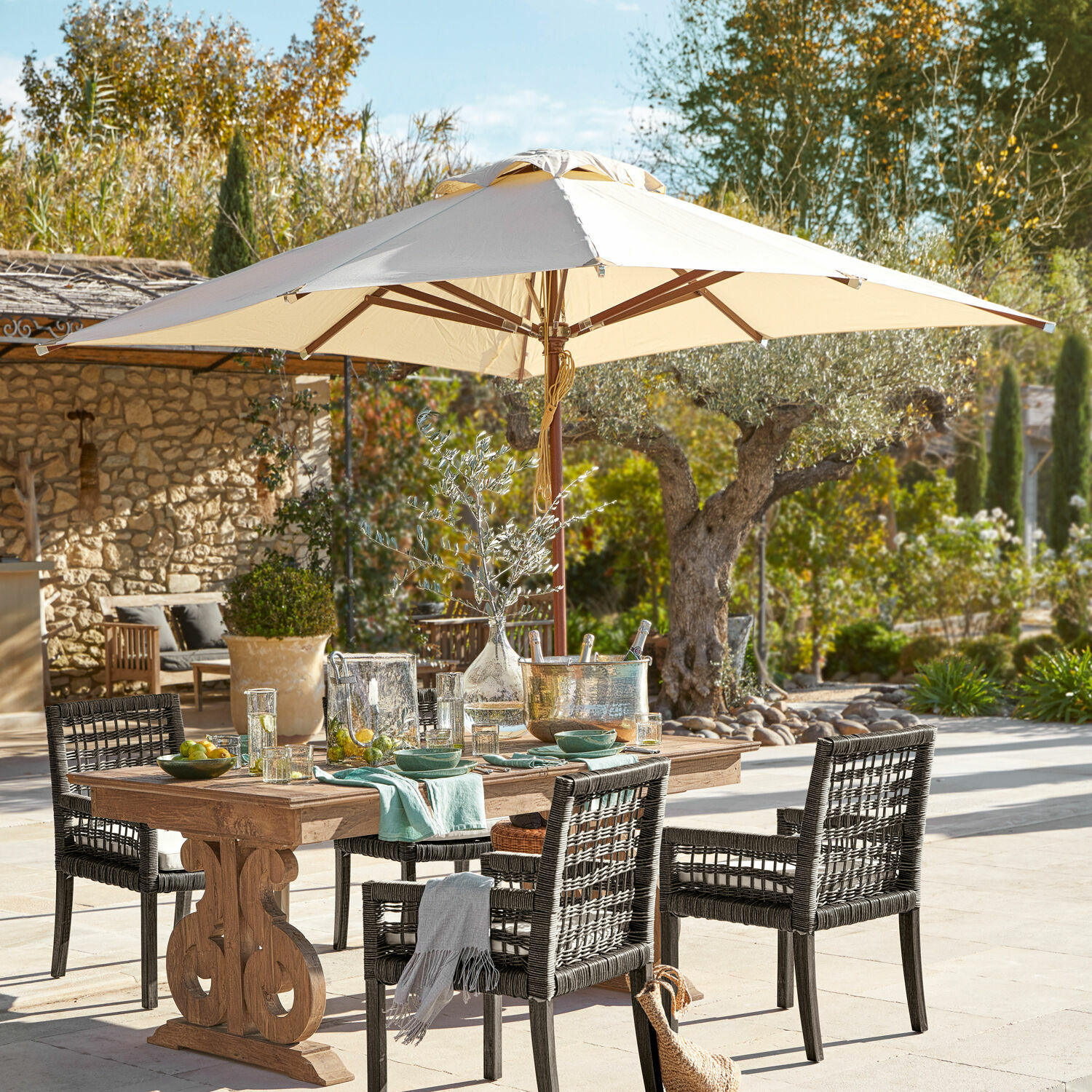 Sombrilla Brent Conjunto de muebles de jardín con mesa de madera y sillas de ratán negro bajo sombrilla beige