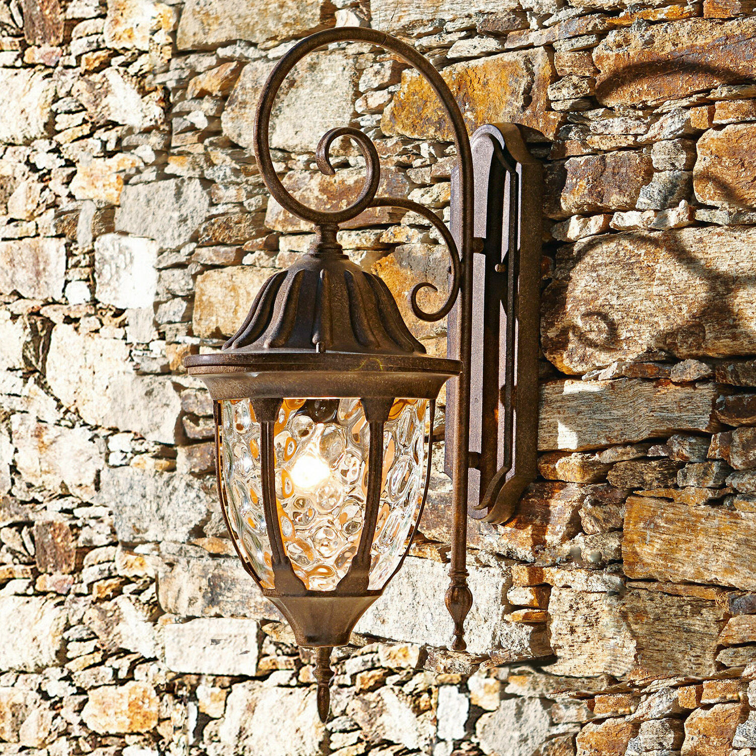 Aplique de exterior Herrère Aplique rústico de metal oxidado con vidrio decorativo en pared de piedra