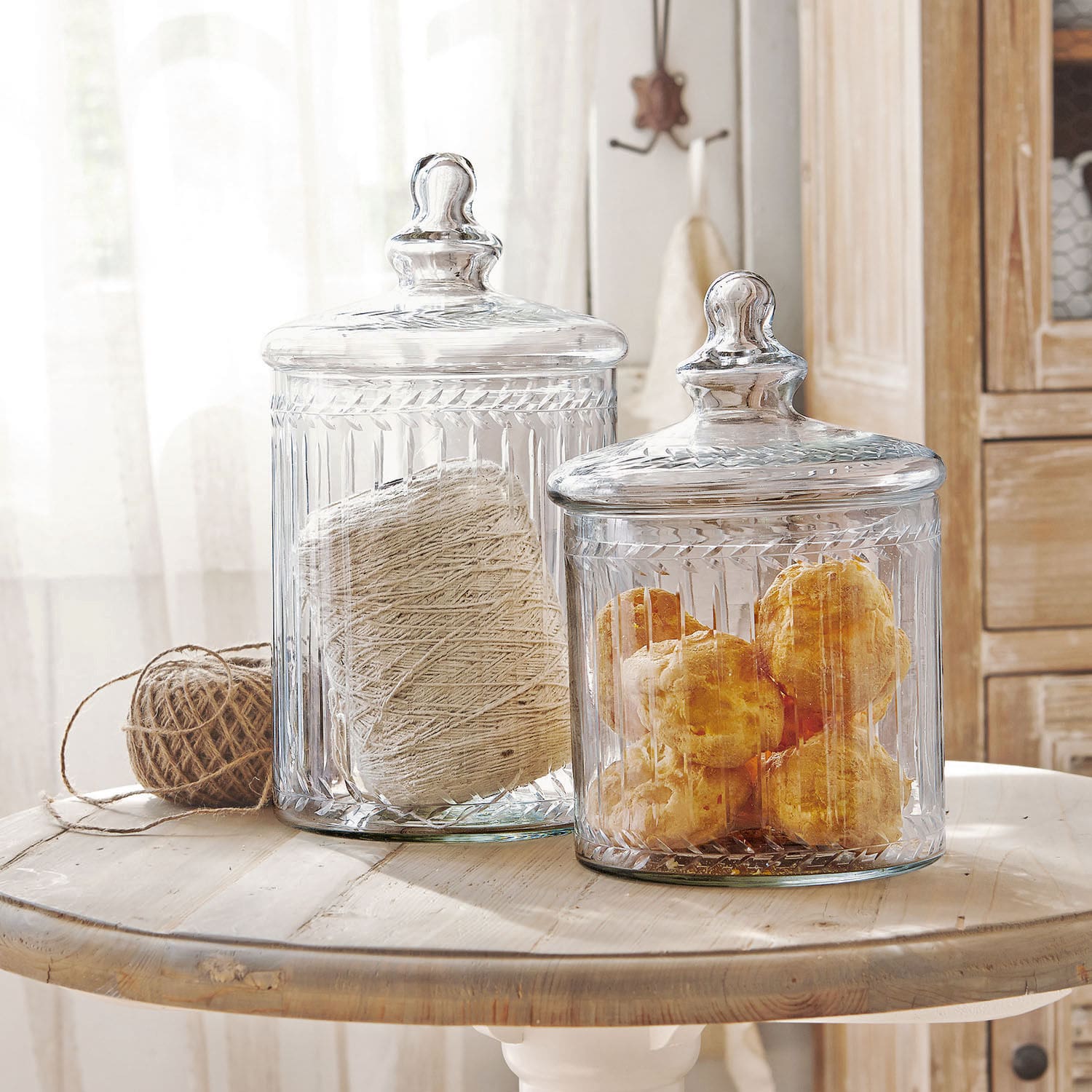 Set de 2 tarros de cristal Maledisant Recipientes de vidrio transparente con tapas que contienen cuerda y bollos sobre una mesa de madera
