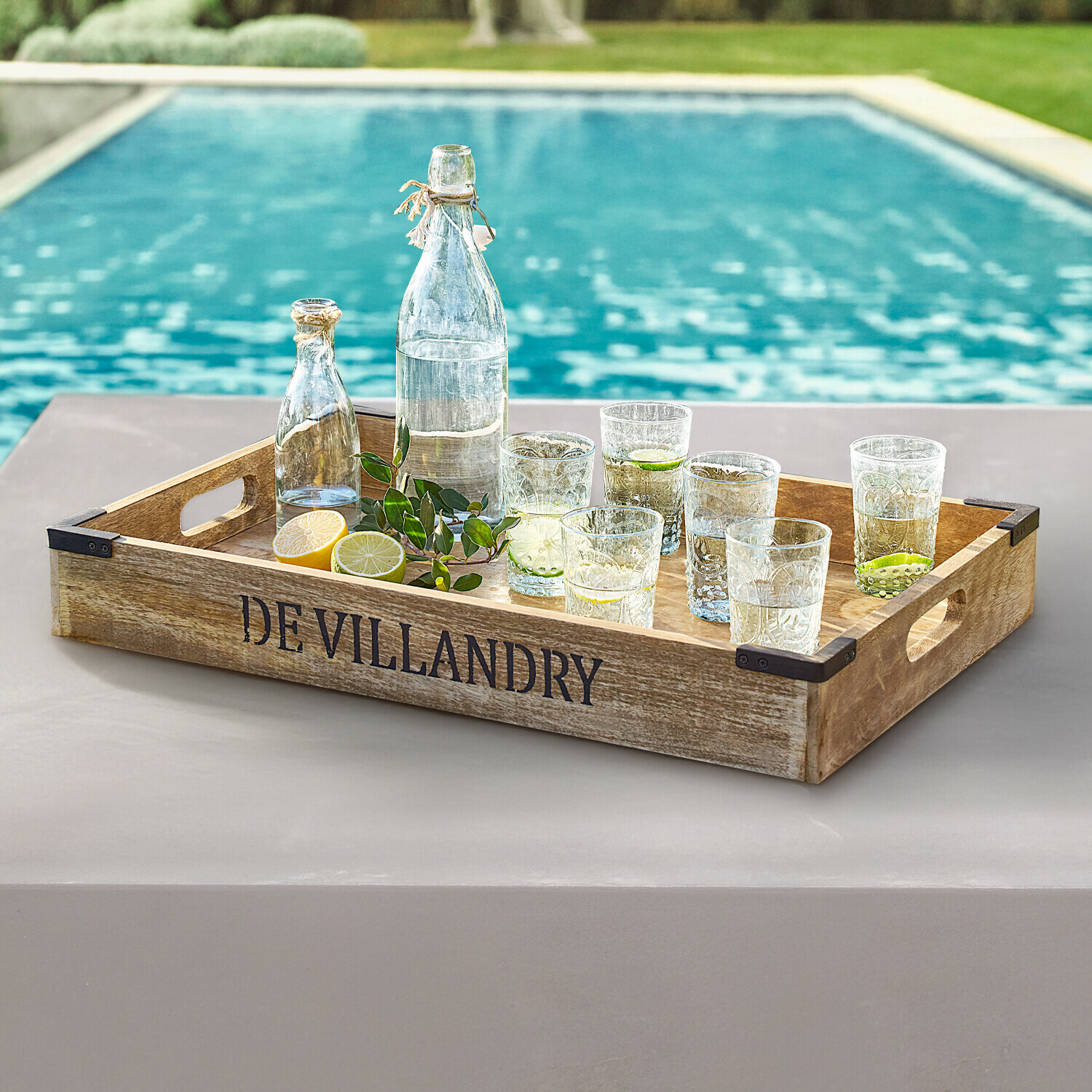 Bandeja Villandry Bandeja de madera DE VILLANDRY con botellas y vasos transparentes junto a la piscina, decoración veraniega