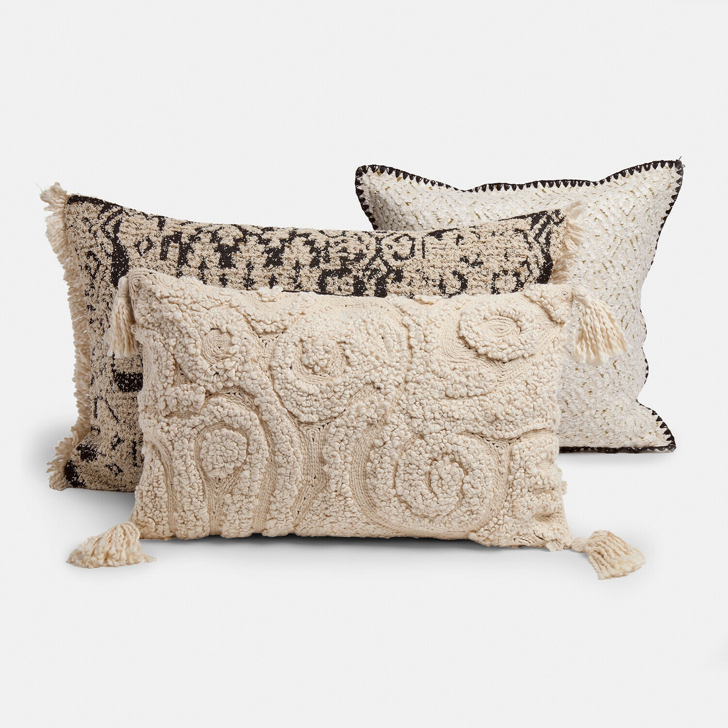Set de 3 fundas de cojín Norlinn Conjunto de tres cojines decorativos en tonos crema y negro con textura y borlas para salón