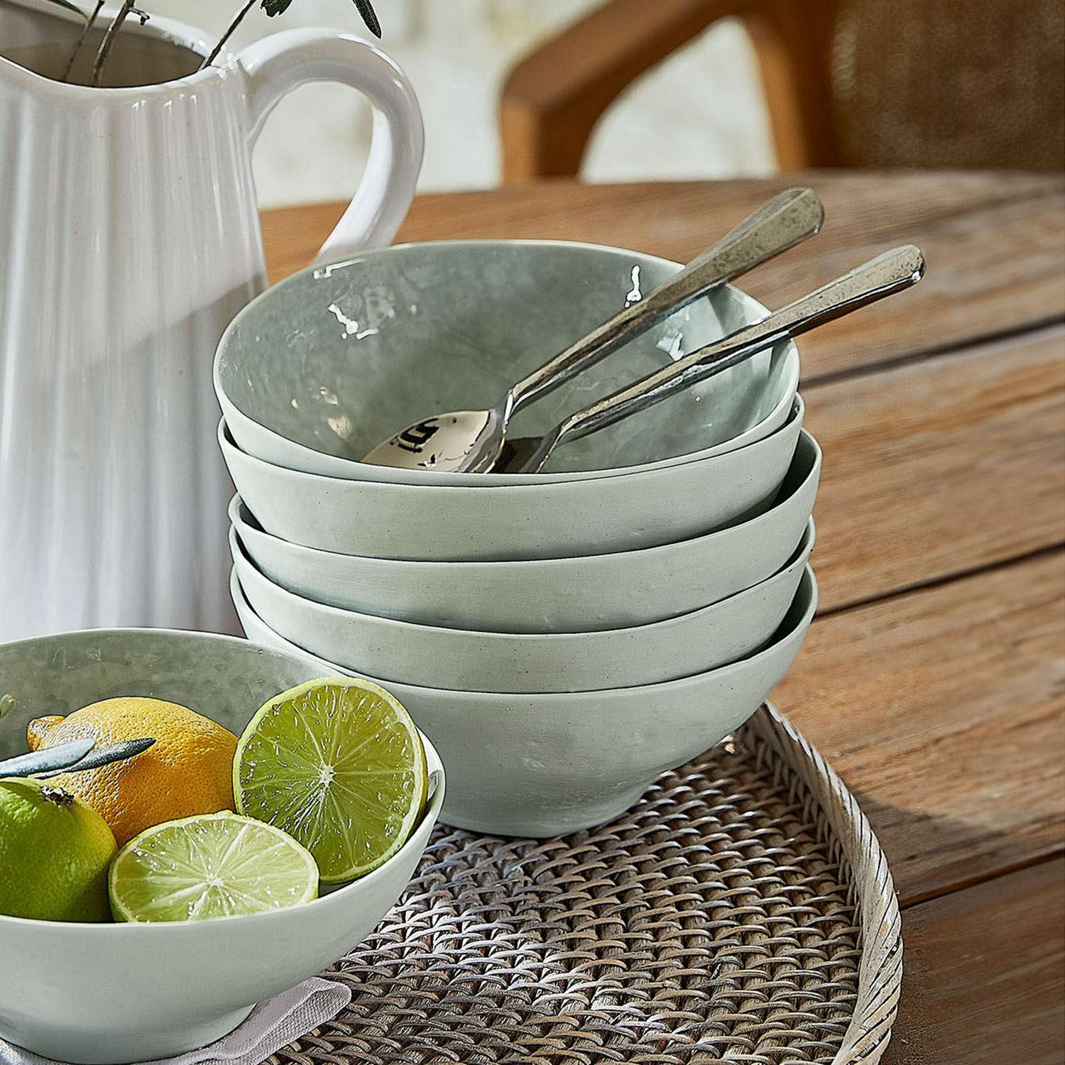 Set de 6 cuencos Braganza Juego de cuencos de cerámica gris sobre bandeja de mimbre con frutas y cucharas
