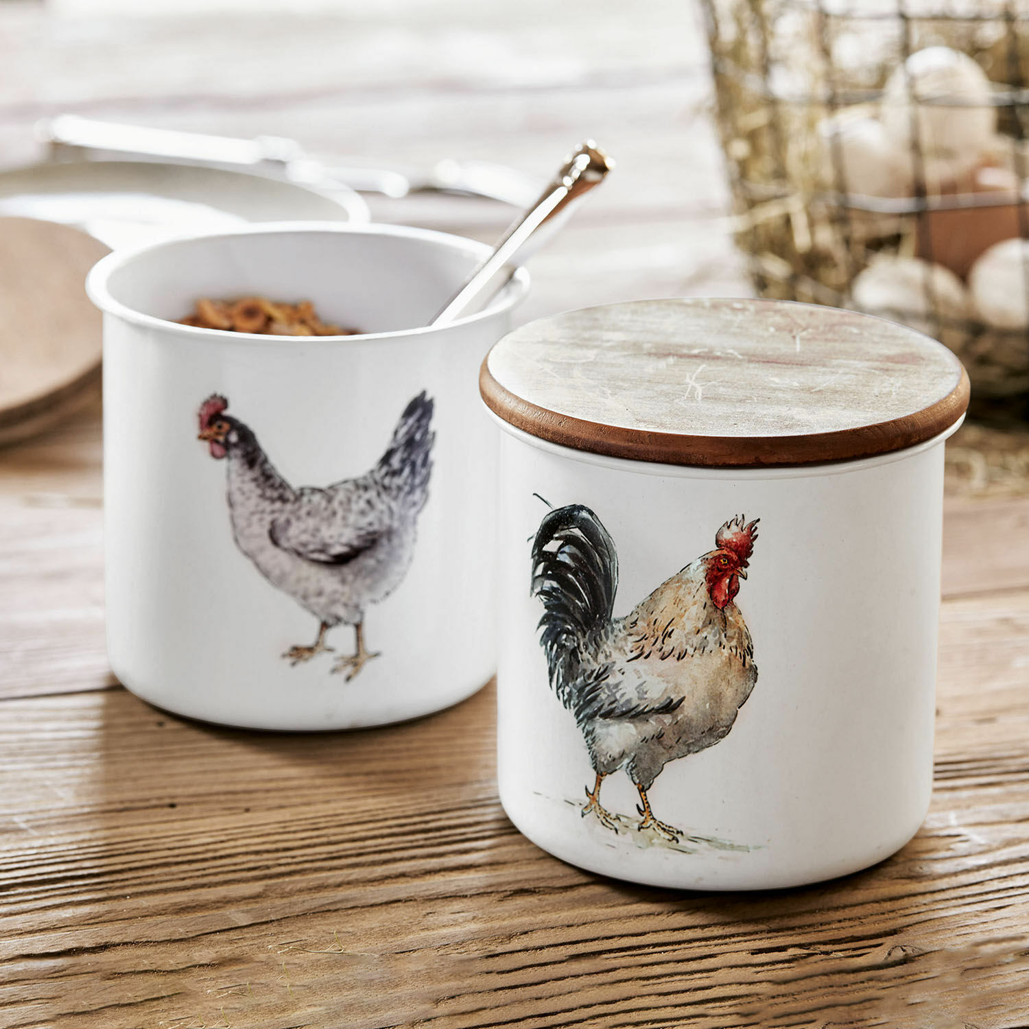 Set de 2 tarros Nobles Recipientes de cerámica blanca con tapa de madera y dibujos de gallina y gallo sobre mesa de madera