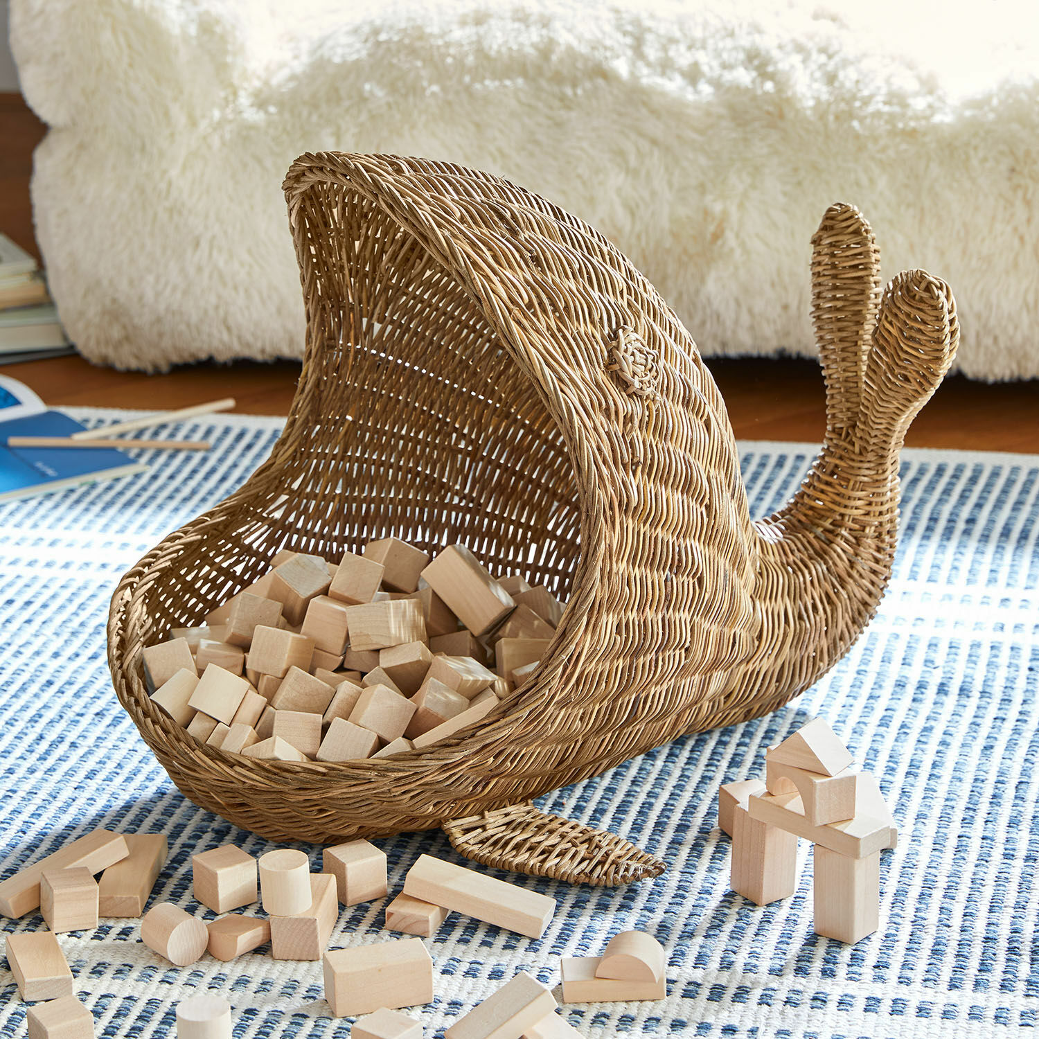 Cesta Cheruboo Cesta de mimbre en forma de ballena natural con bloques de madera sobre alfombra azul