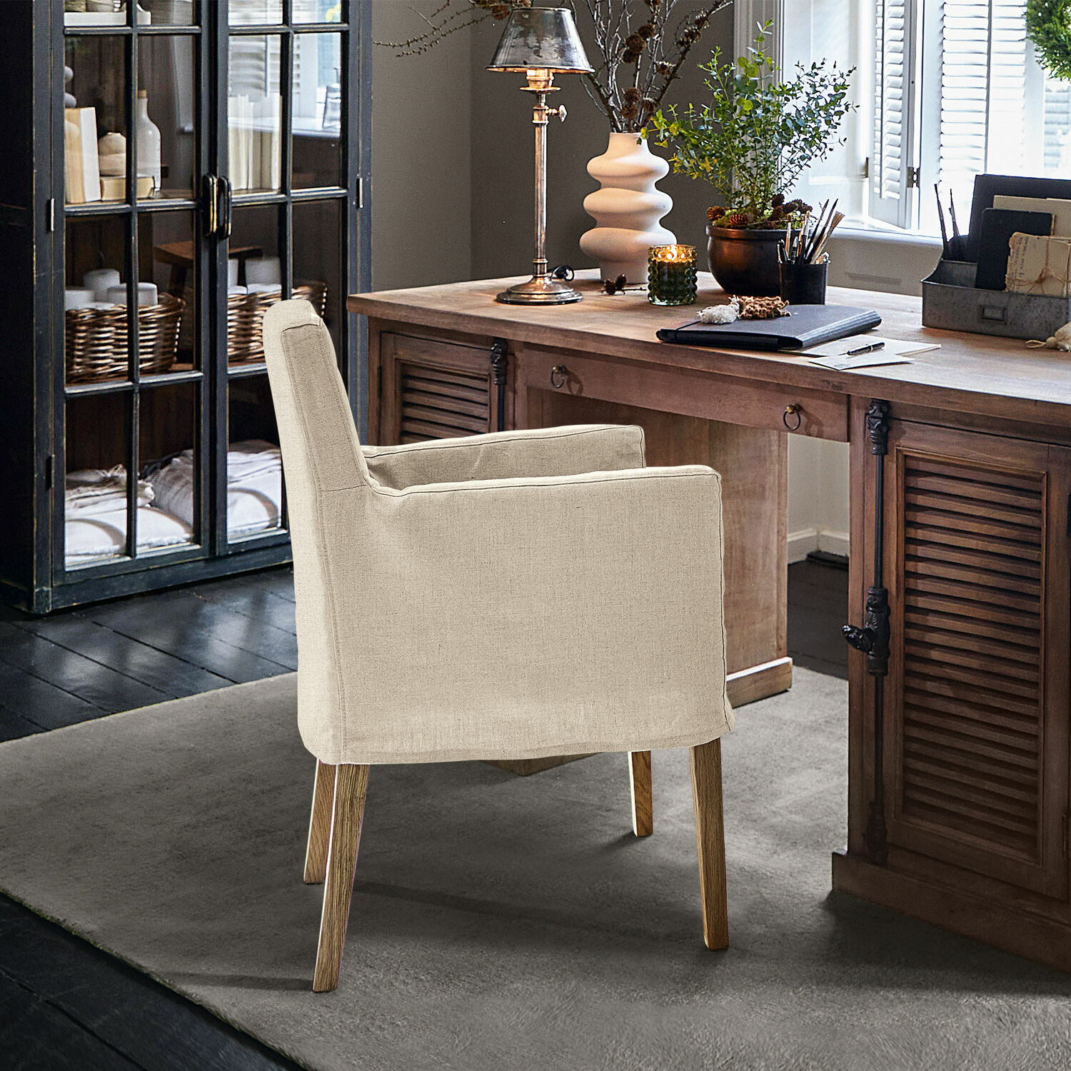 Sillón beige de tela con patas de madera en oficina elegante con escritorio de madera