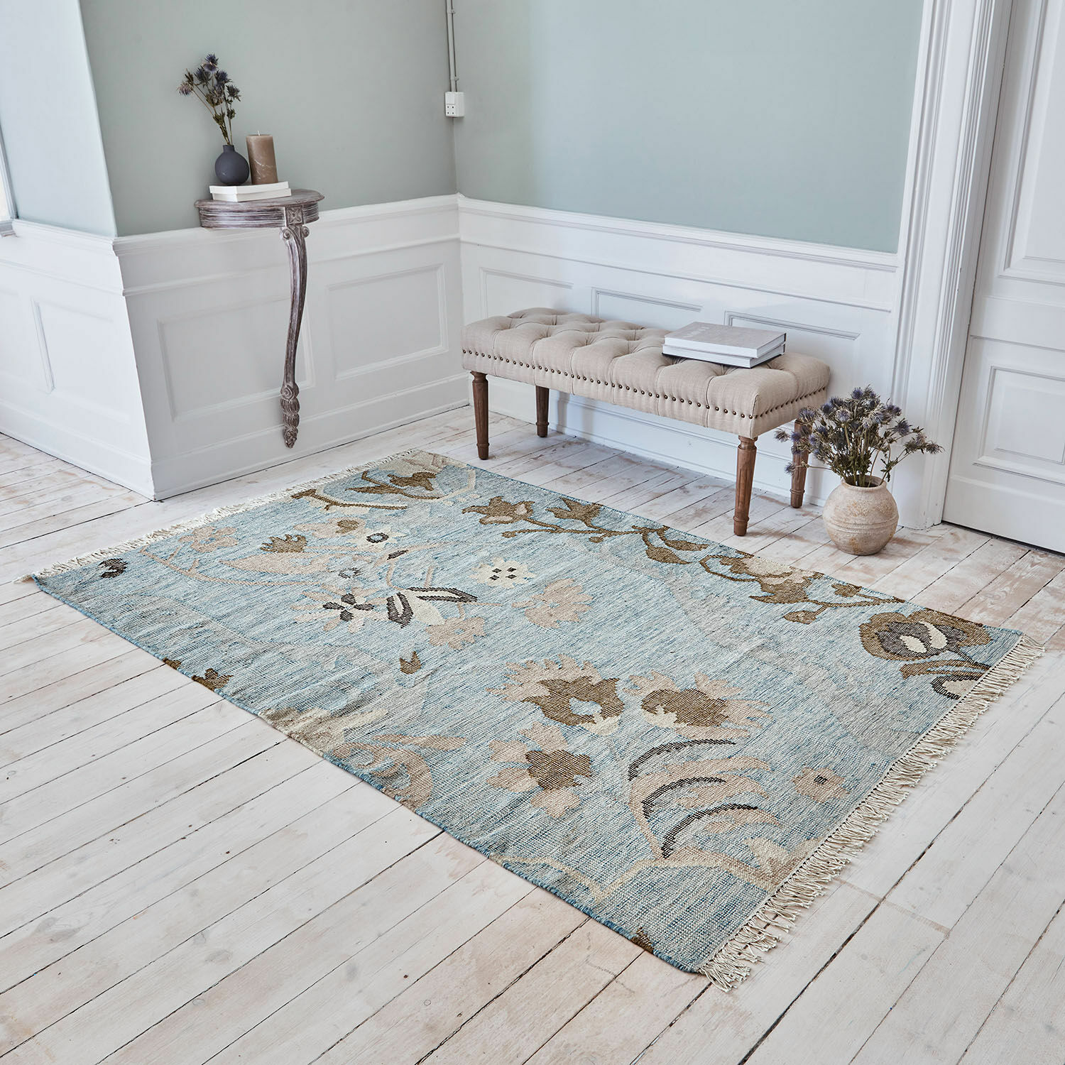Alfombra Nére Alfombra con diseño floral en tonos azules y beige sobre suelo de madera clara en habitación elegante