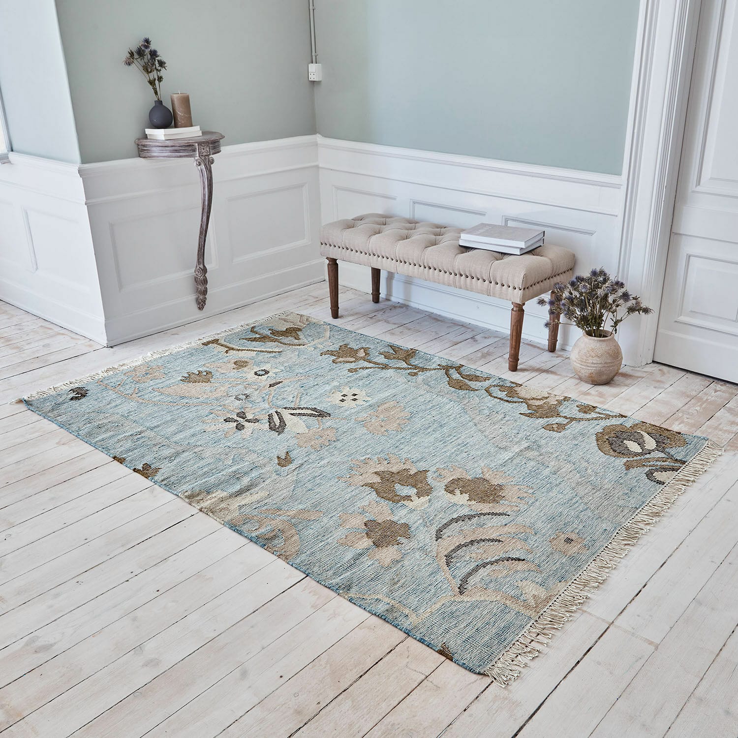 Alfombra Nére Alfombra con diseño floral en tonos azules y beige sobre suelo de madera clara en habitación elegante