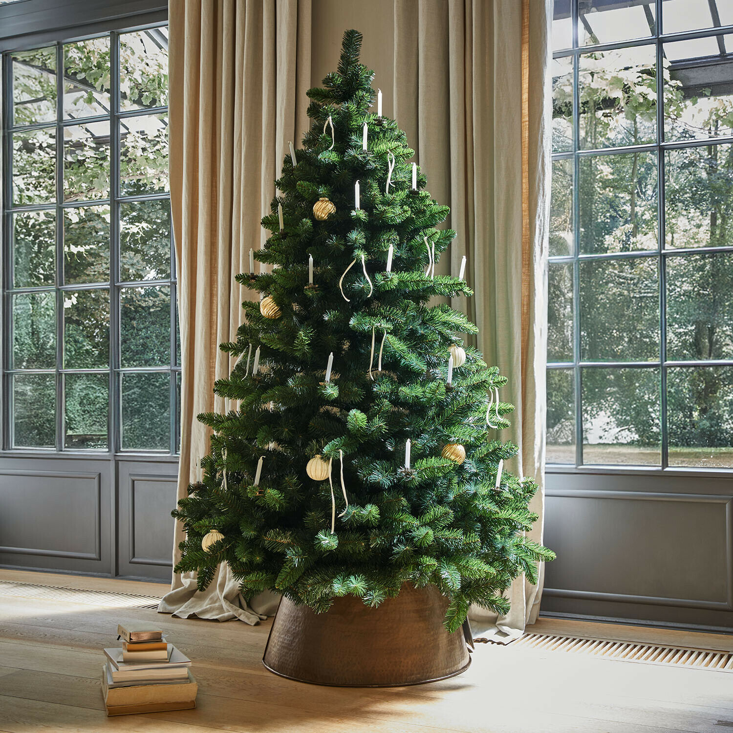 Árbol de Navidad Bryndis Árbol de Navidad artificial verde con velas blancas en maceta de cobre junto a ventana con cortinas beige