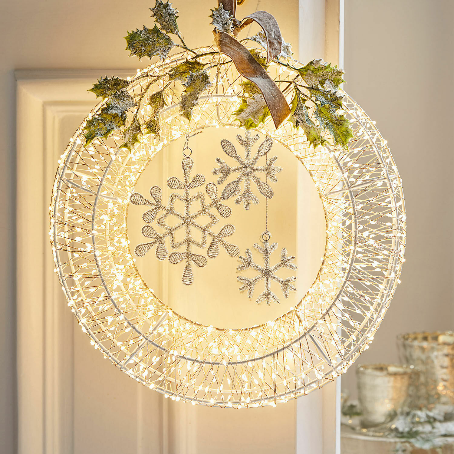 Guirnalda LED Winsloe Corona navideña de alambre blanco con luces LED y adornos brillantes en forma de copos de nieve