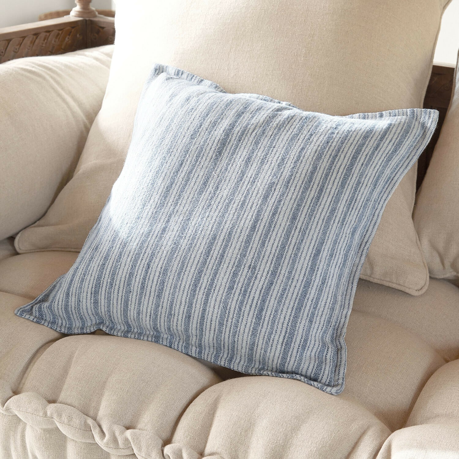 Funda de cojín Freydaal Cojín decorativo de algodón con rayas azul y blanco sobre sofá beige, accesorio moderno para hogar