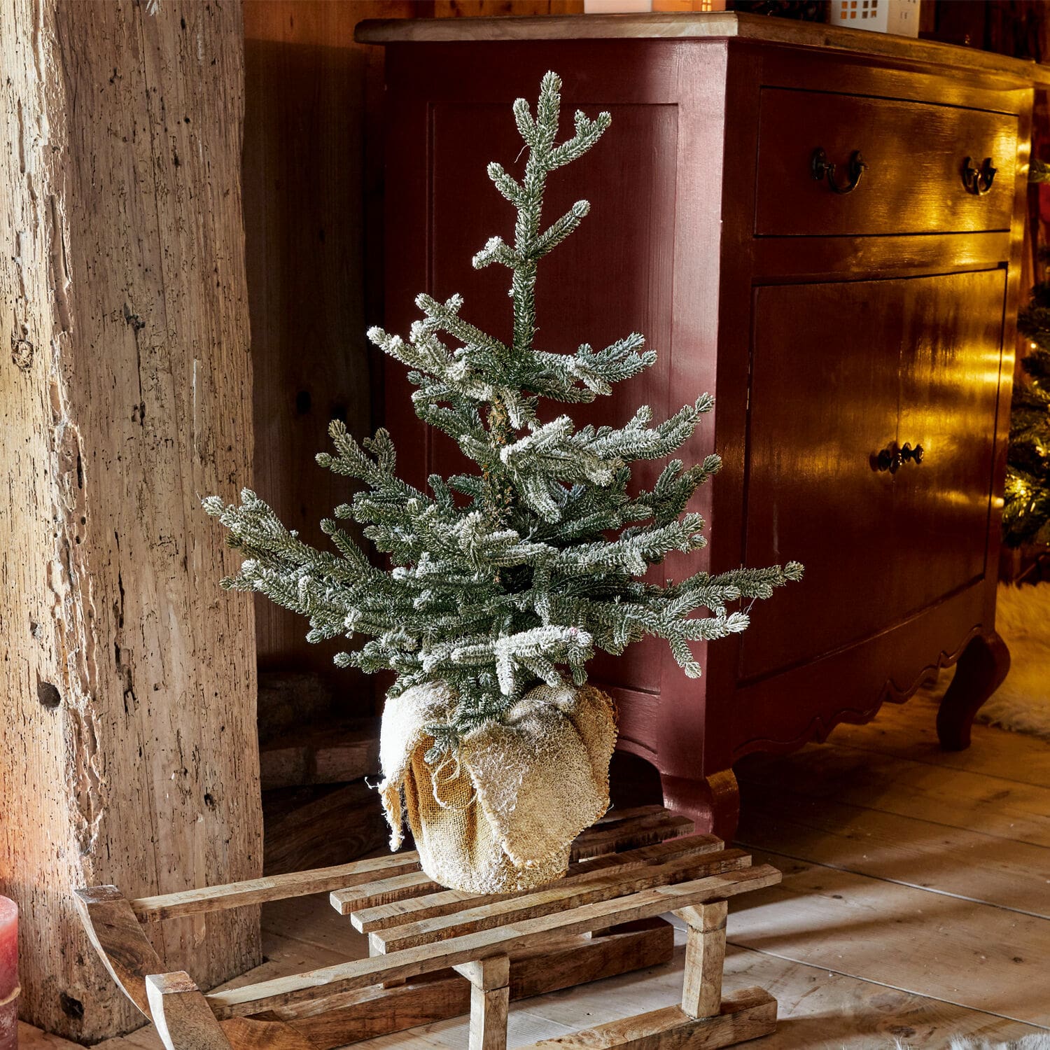 Árbol decorativo Glenda Pequeño árbol de Navidad artificial con nieve sobre trineo de madera en ambiente rústico