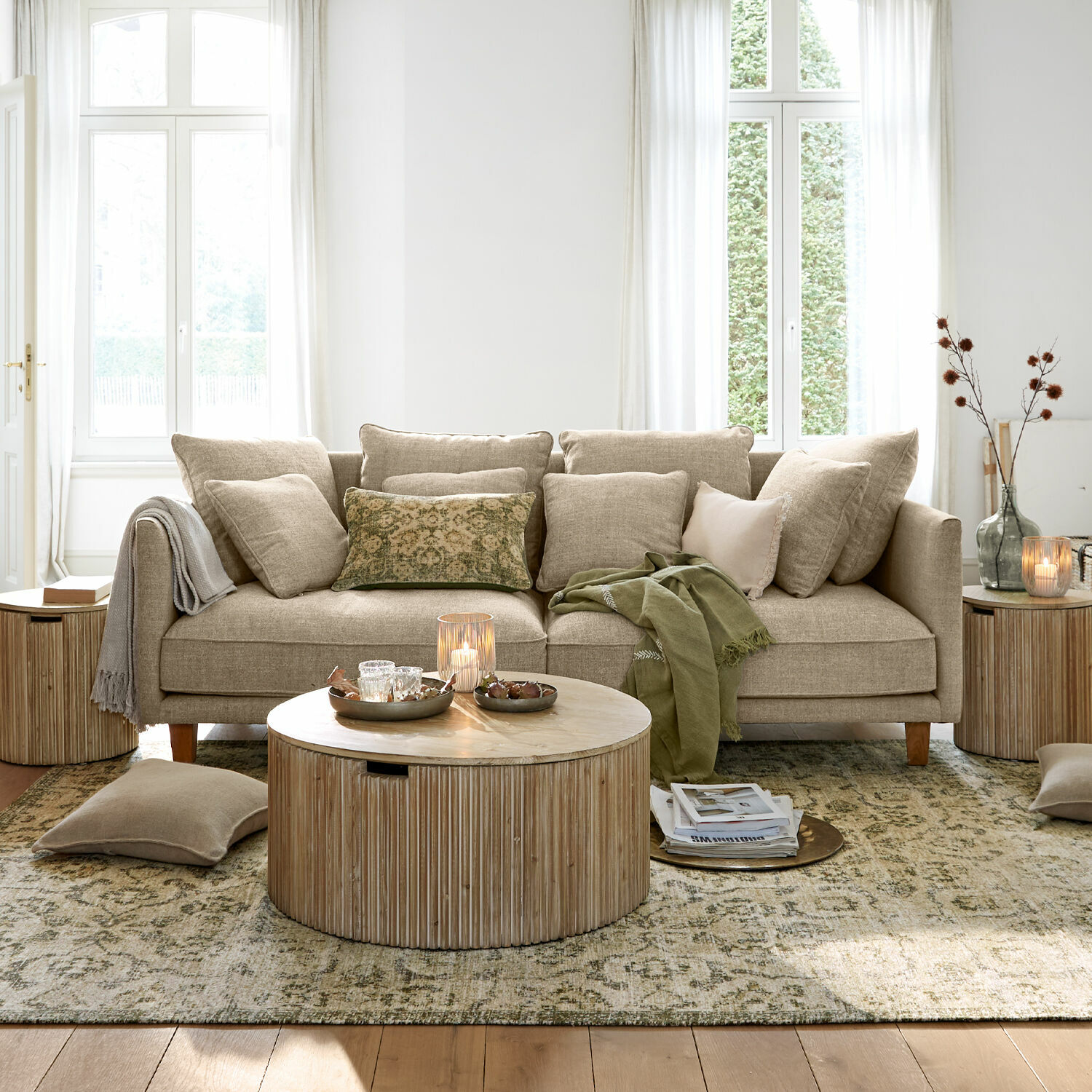 Sofá beige de tela con cojines y mesa de centro de madera en sala luminosa
