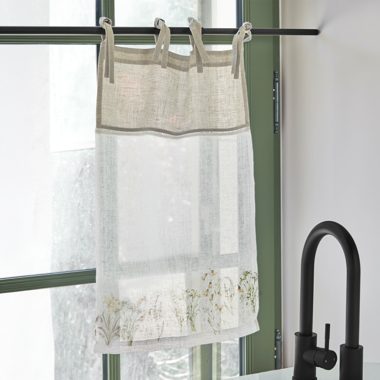 Visillo Lozere Cortina de lino beige y blanca con delicado diseño floral, colgada en barra negra junto a grifo negro