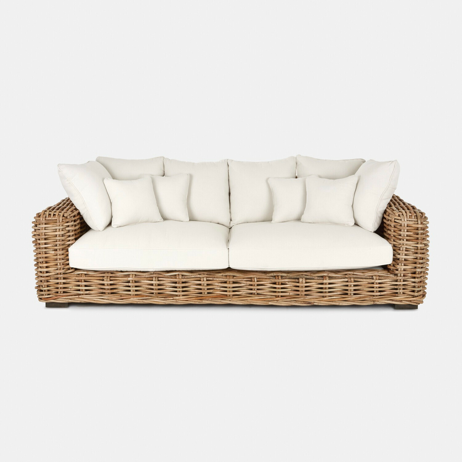 Sofá de ratán con cojines blancos y asiento mullido, mueble cómodo para salón