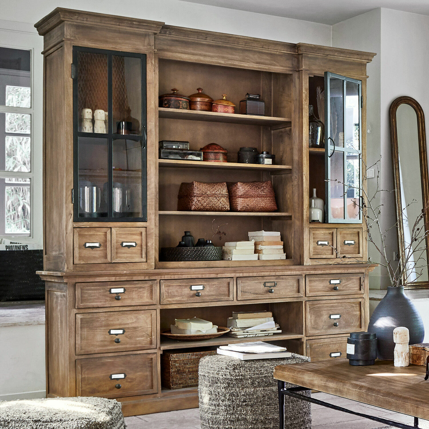 Armario Horsens Gran vitrina de madera natural con cajones y puertas de cristal en salón luminoso