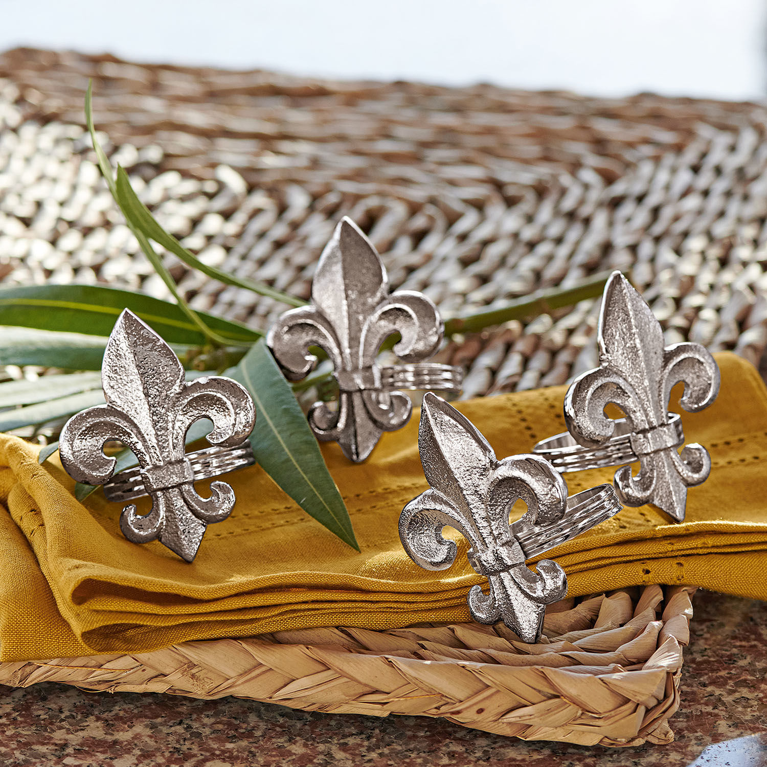 Set de 4 servilleteros Fleur De Lis Anillos de servilleta de metal plateado con diseño de flor de lis sobre tela amarilla y bandeja de mimbre