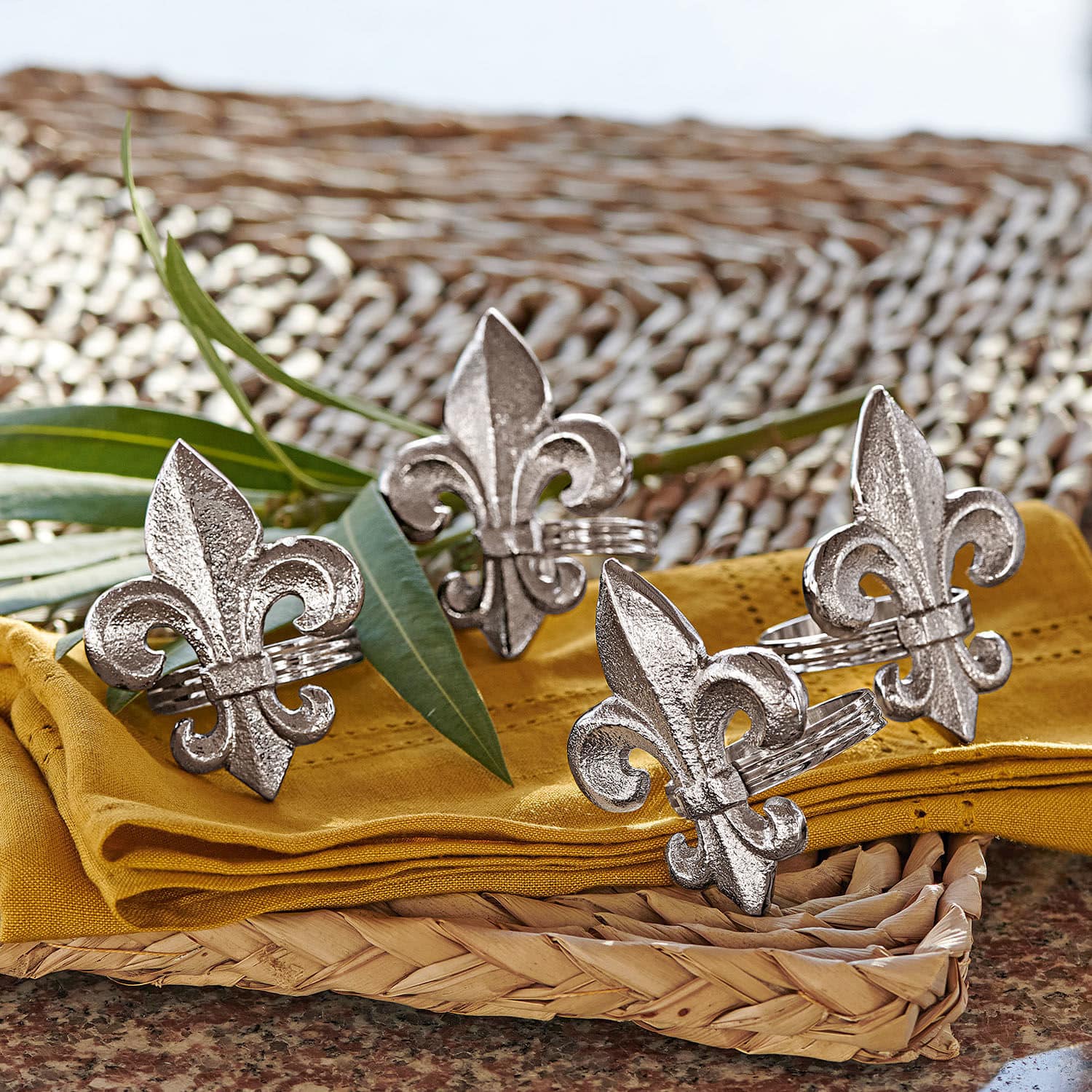 Set de 4 servilleteros Fleur De Lis Anillos de servilleta de metal plateado con diseño de flor de lis sobre tela amarilla y bandeja de mimbre