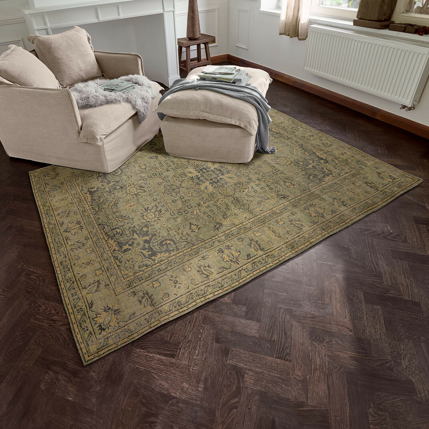 Alfombra Marouan Alfombra beige con diseño oriental sobre suelo de madera oscura en sala con sillón beige