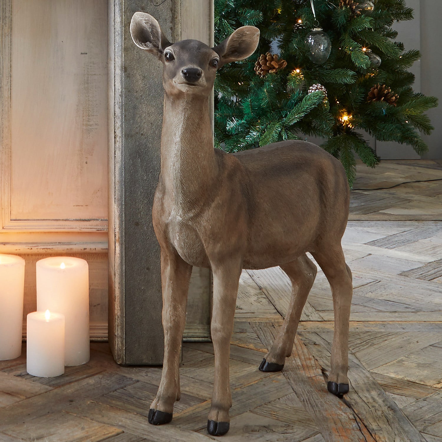 Cierva Ruud Figura decorativa de ciervo marrón junto a árbol de Navidad iluminado y velas