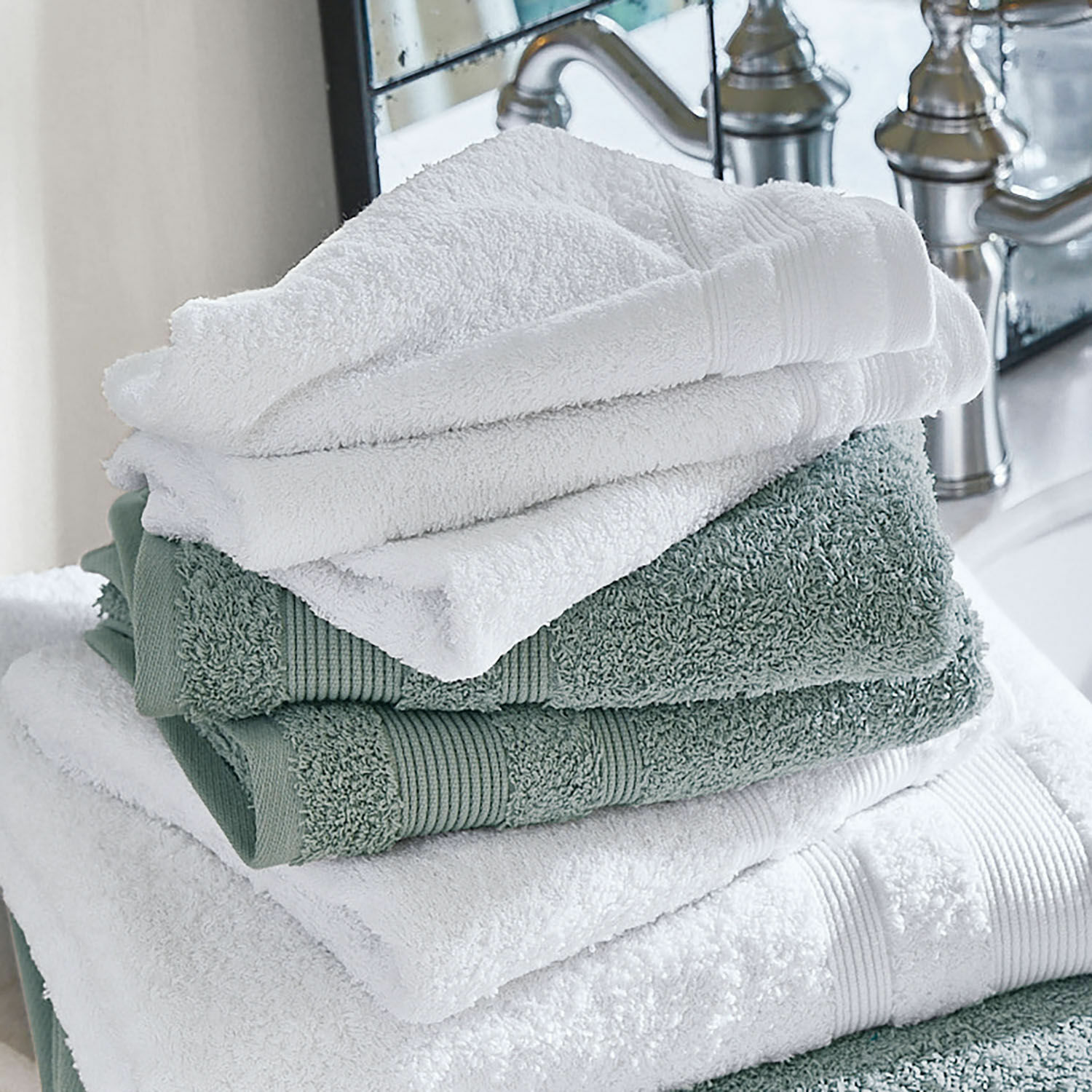 Set de 4 toallas Bourogne Toallas de algodón suaves en blanco y verde apiladas en baño con grifo metálico