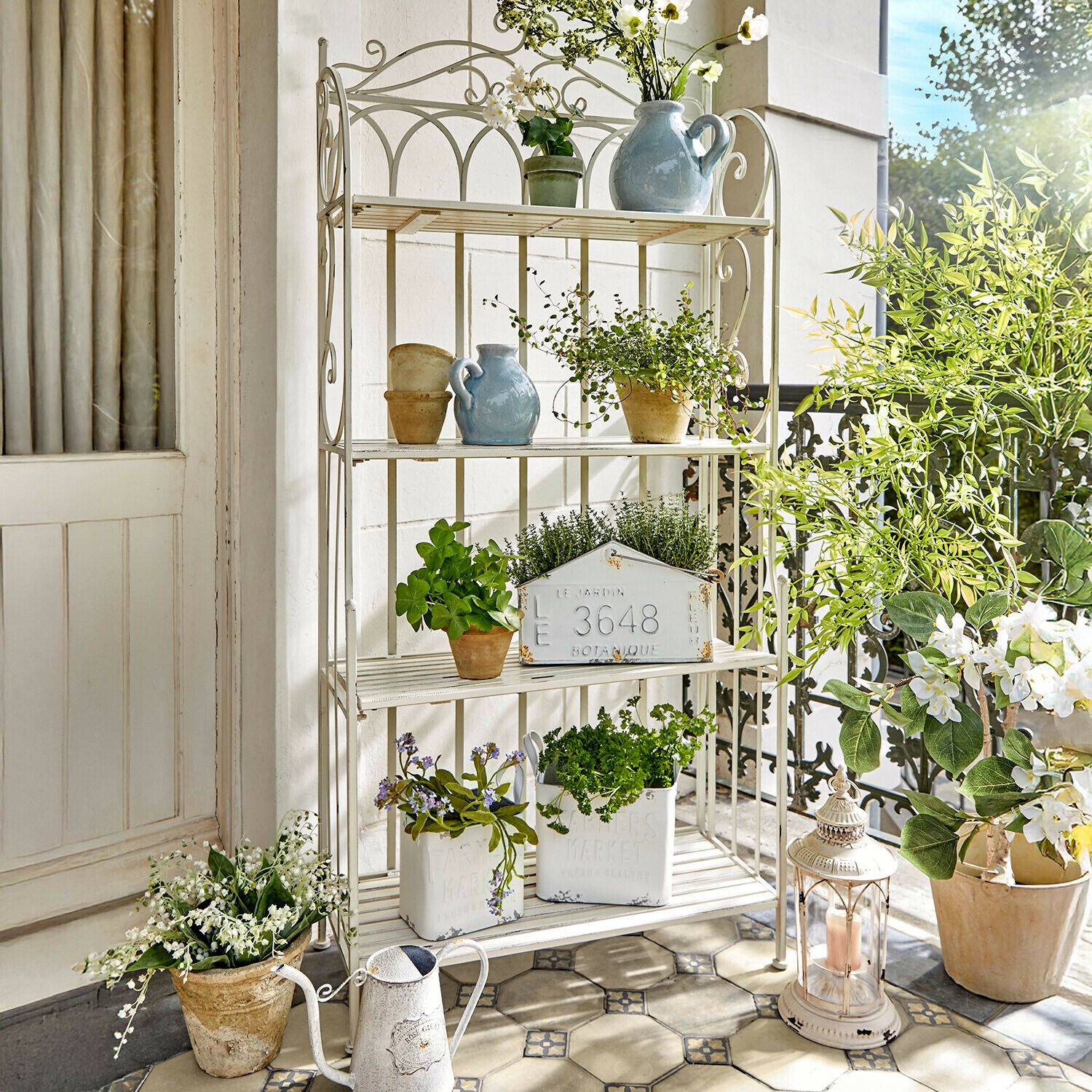 Estante Cruis Estantería metálica blanca con plantas en macetas y decoraciones en balcón luminoso