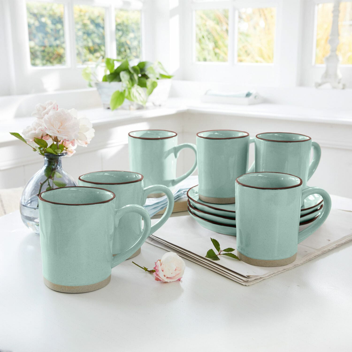 Set de 6 tazas Biarré Juego de seis tazas de cerámica verde menta con borde marrón sobre mesa blanca