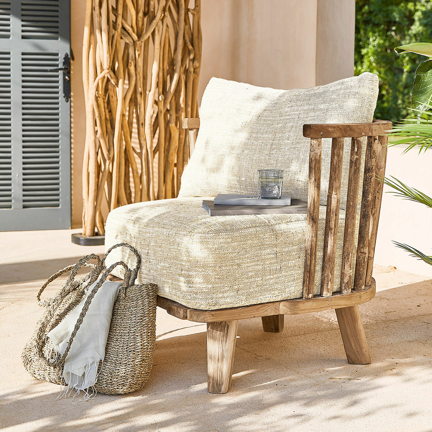 Sillón con tapizado beige claro y estructura de madera, ideal para relajarse en la terraza