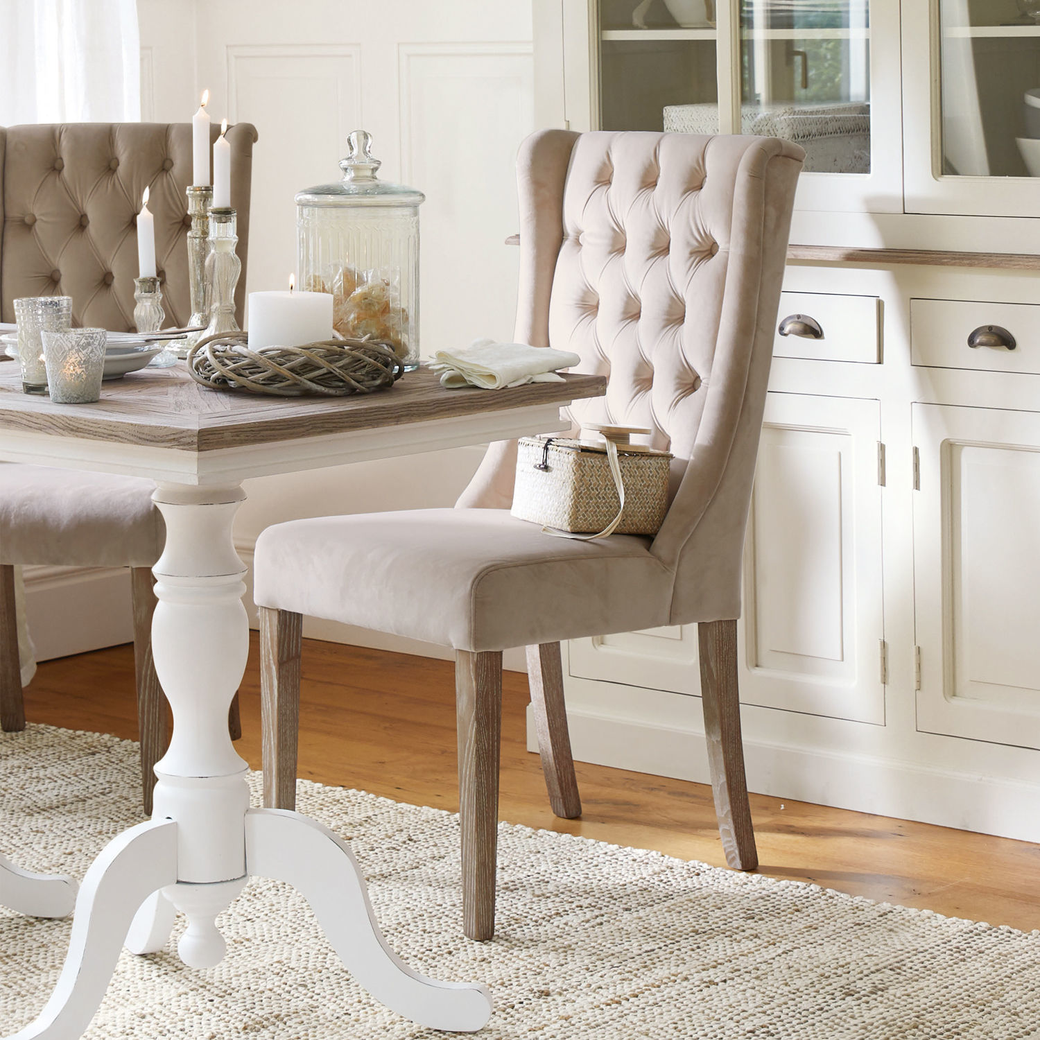 Silla Sudbury Silla tapizada beige con patas de madera en comedor elegante con alfombra y mesa blanca