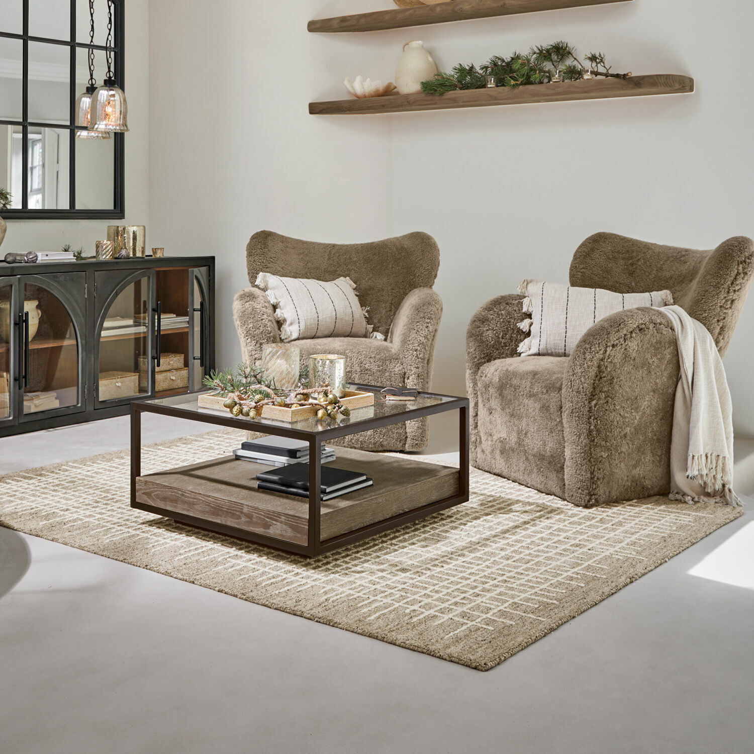 Sillones acogedores de peluche marrón en salón moderno con mesa de centro de cristal y alfombra estampada