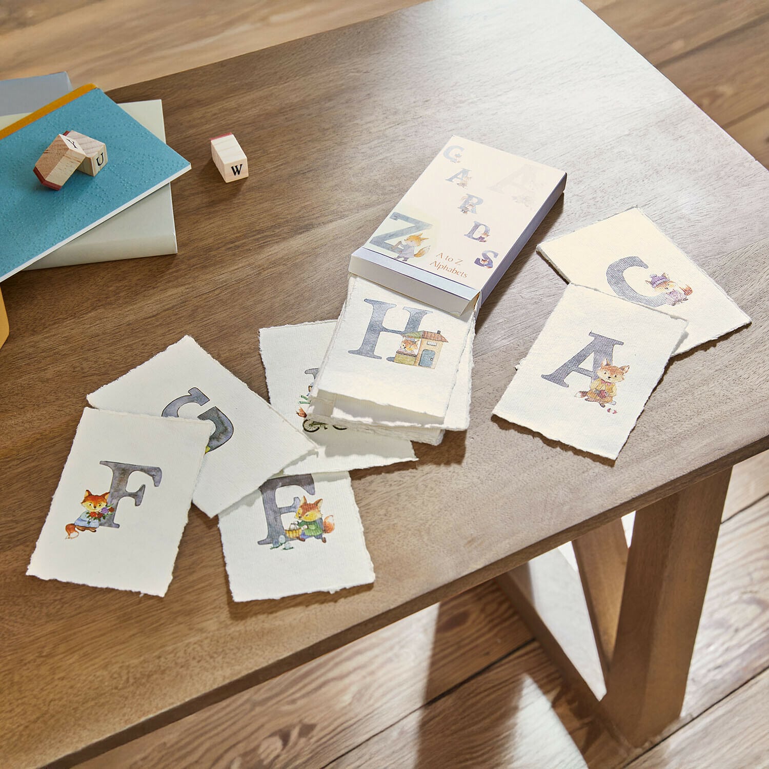 Conjunto de cartas educativas con alfabeto e ilustraciones de animales sobre mesa de madera para aprender letras