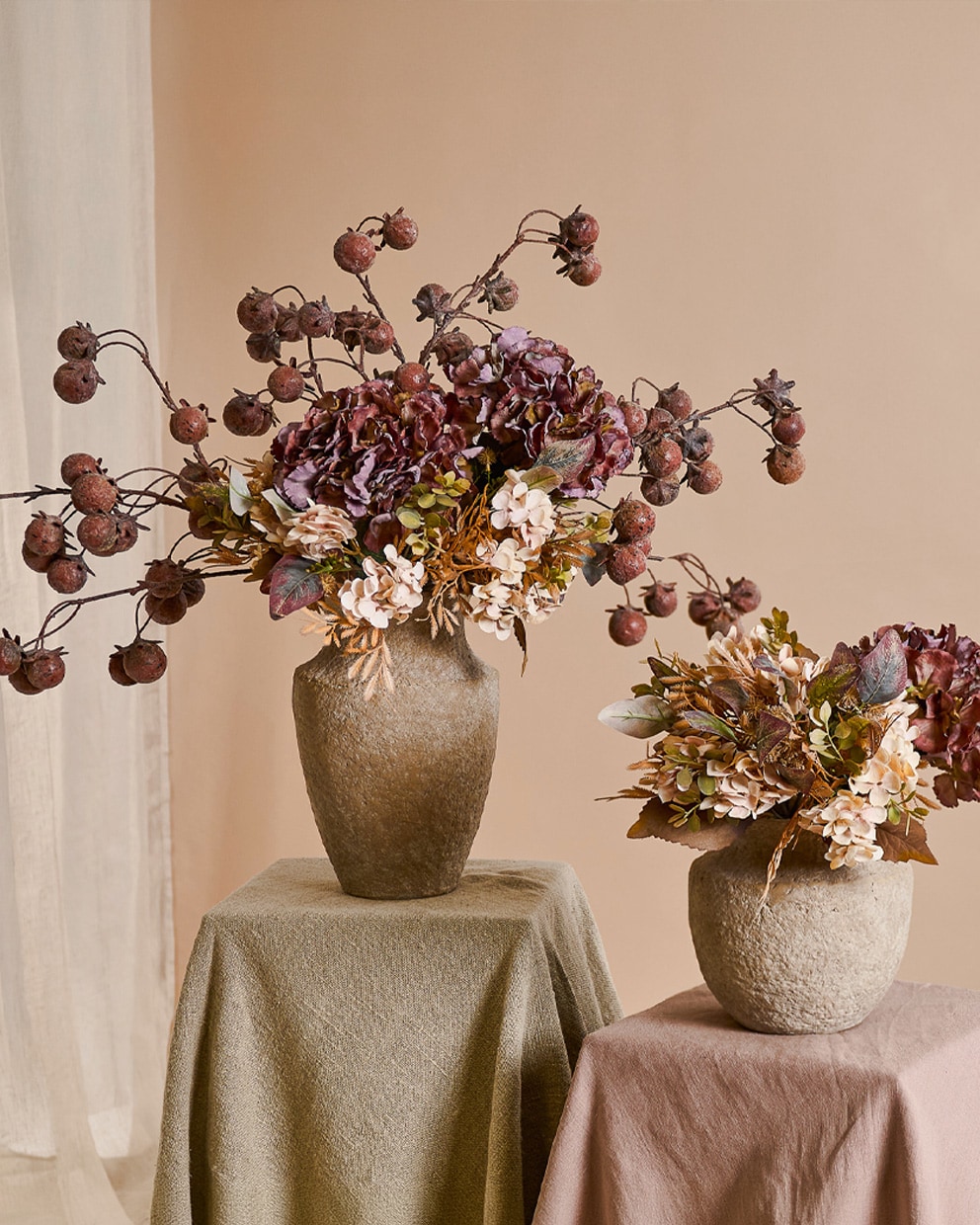 Dos jarrones de piedra con flores otoñales y frutos secos en tonos cálidos beige y marrón para decoración interior