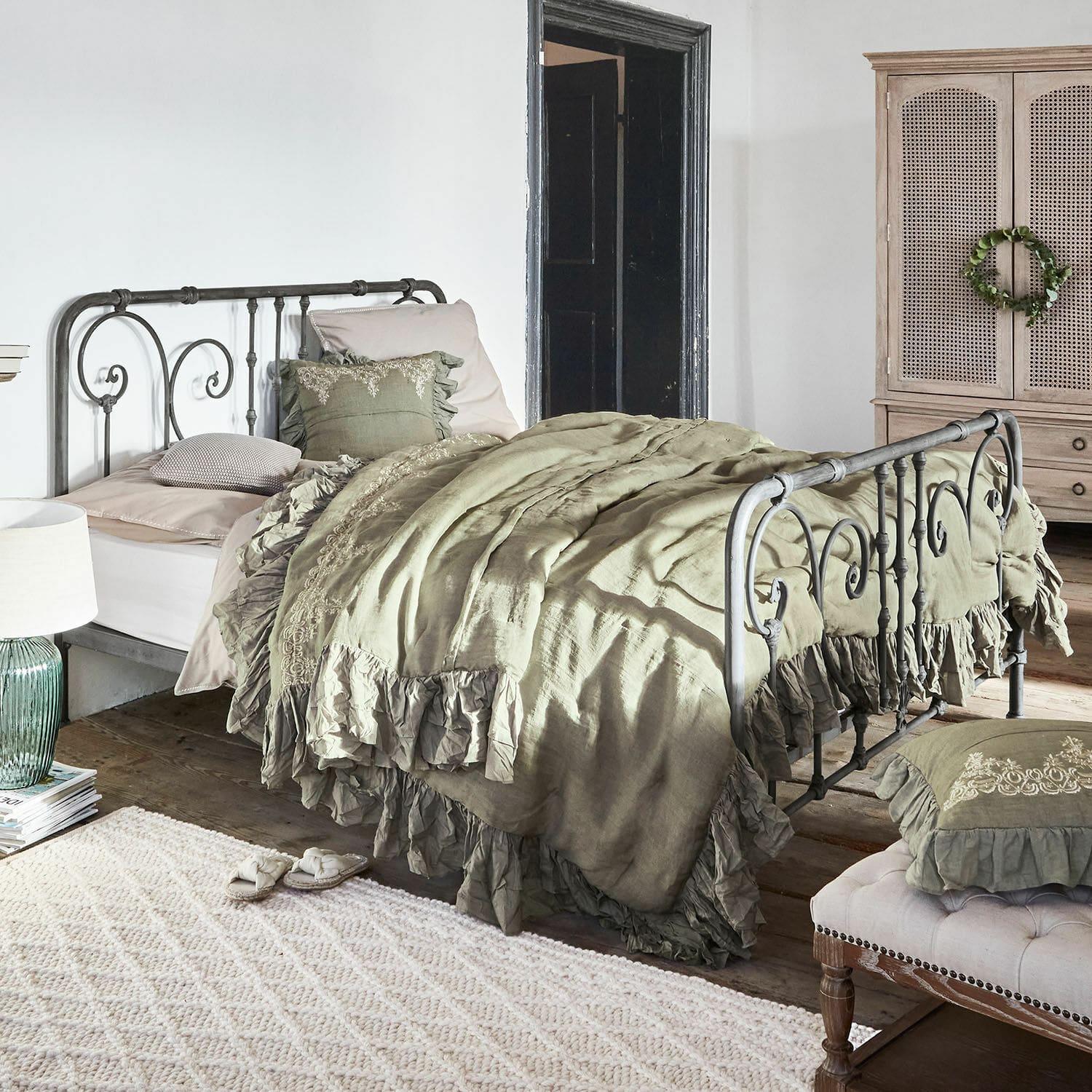 Cama Genouillé Cama de metal con ropa de cama verde de lino con volantes en dormitorio rústico