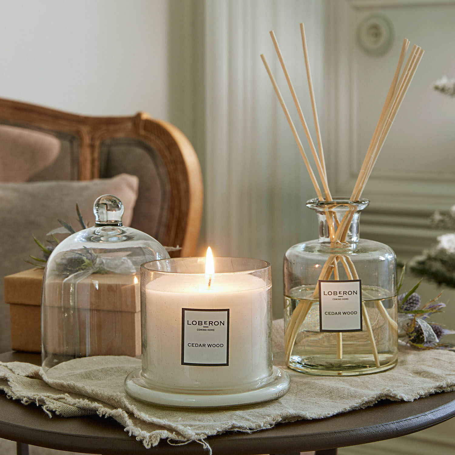 Set de fragancias Vanis Vela aromática y difusor de madera de cedro en recipientes de vidrio sobre mesa decorativa
