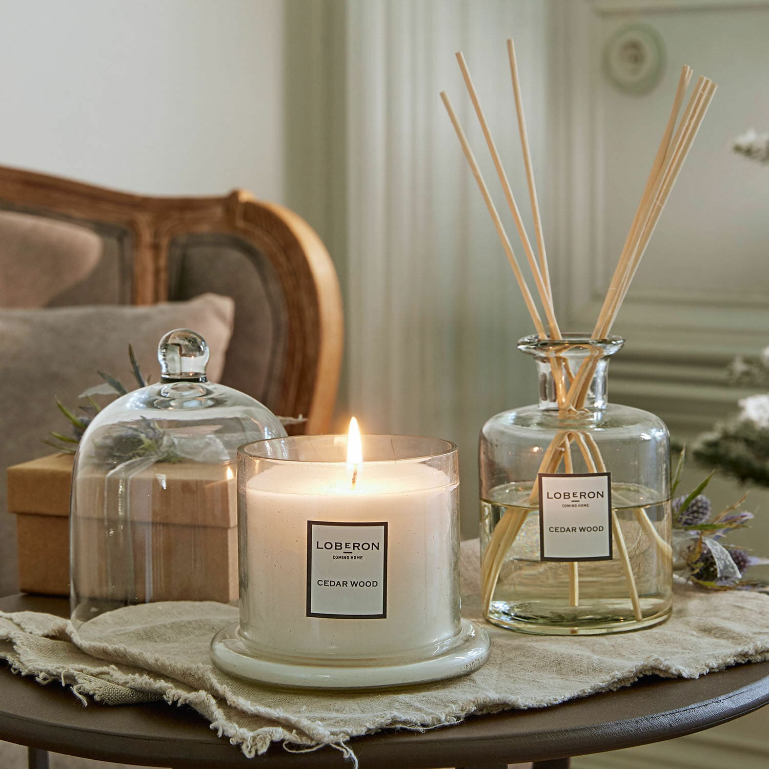 Set de fragancias Vanis Vela aromática y difusor de madera de cedro en recipientes de vidrio sobre mesa decorativa