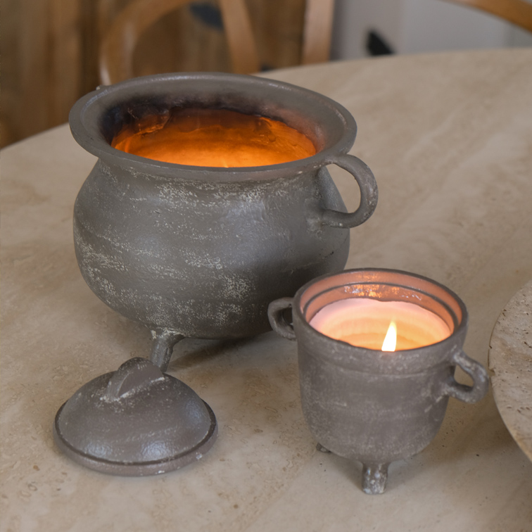Conjunto de dos portavelas de metal gris, uno con tapa, sobre mesa clara