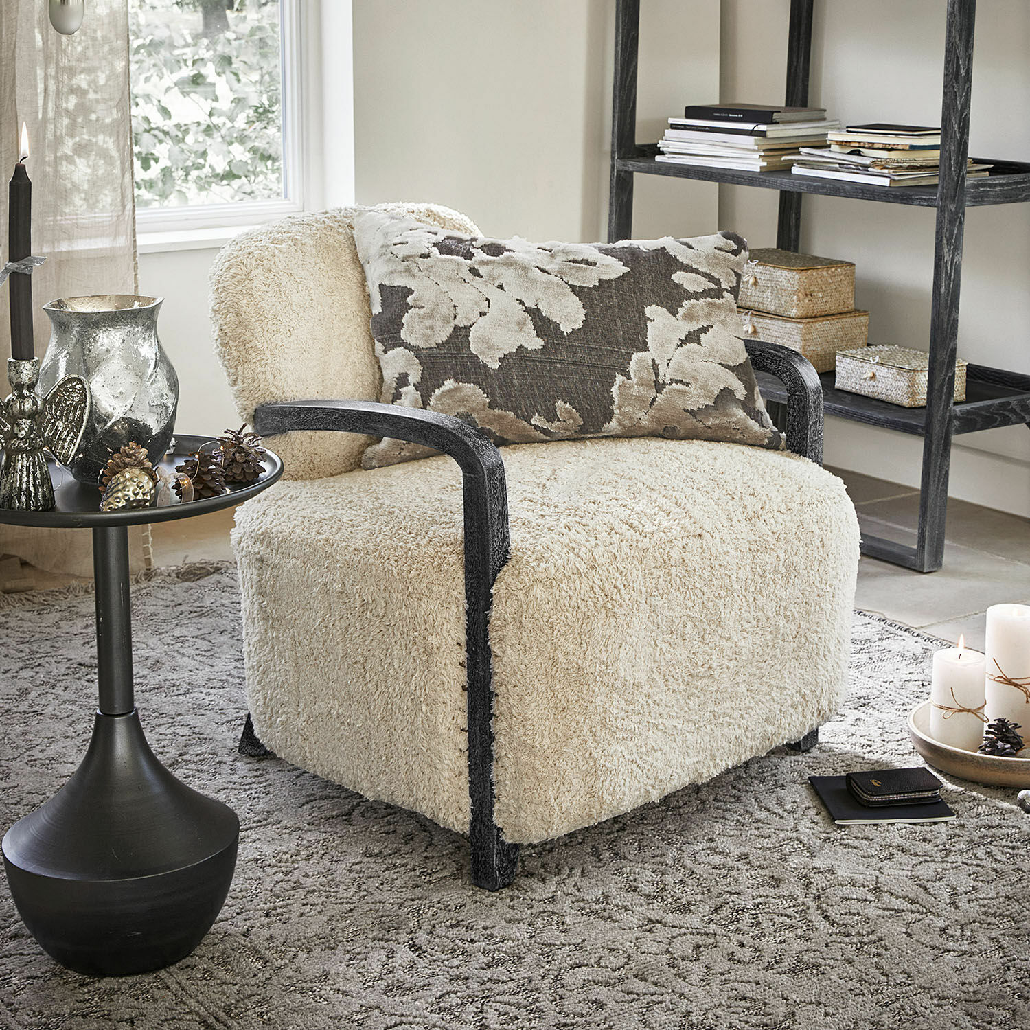 Sillón Roudaria Sillón con tapizado crema suave y reposabrazos de madera negra en una sala acogedora
