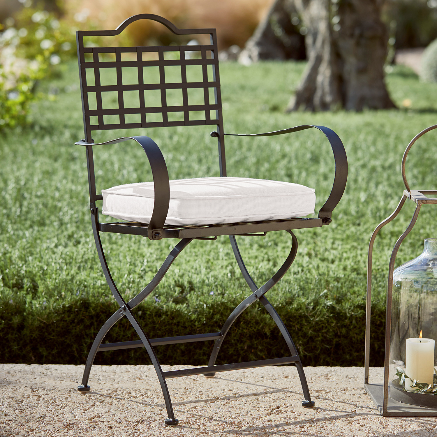 Silla de jardín de metal negro con cojín blanco, perfecta para relajarse al aire libre