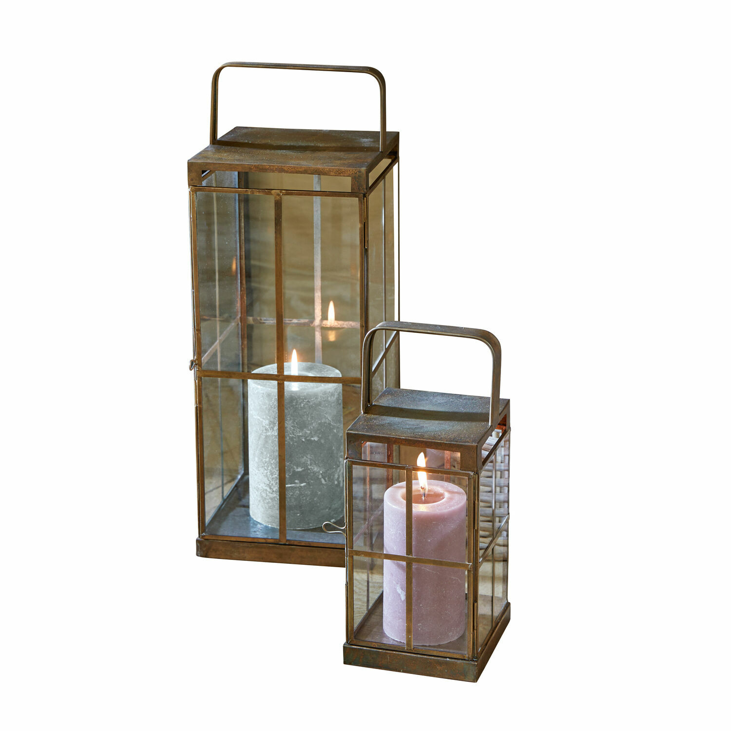Set de 2 linternas Garrett Park Conjunto de dos faroles de metal con asas y velas encendidas tras paredes de cristal