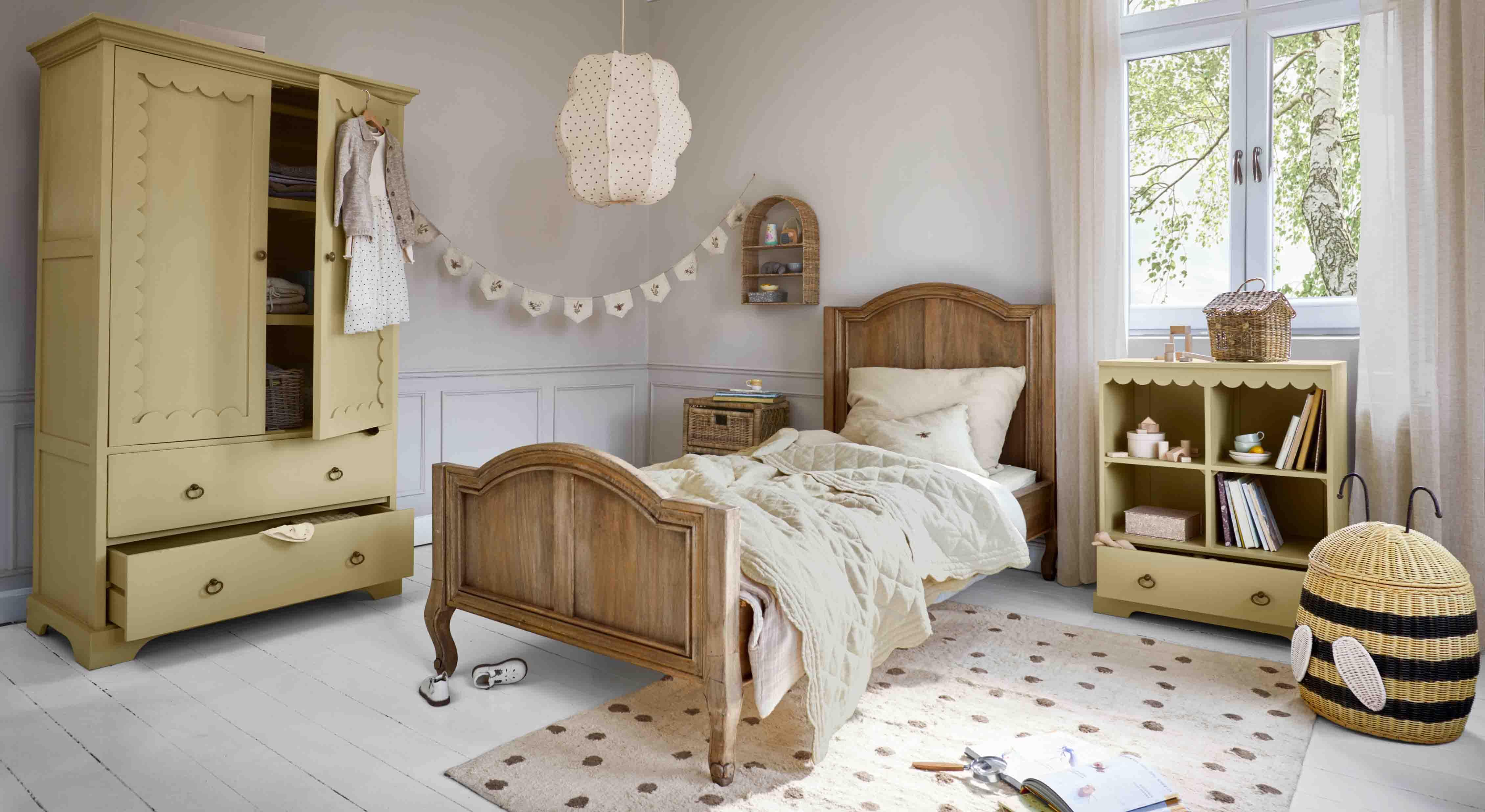 Acogedora habitación infantil con cama de madera, armario amarillo y estantería de madera y mimbre