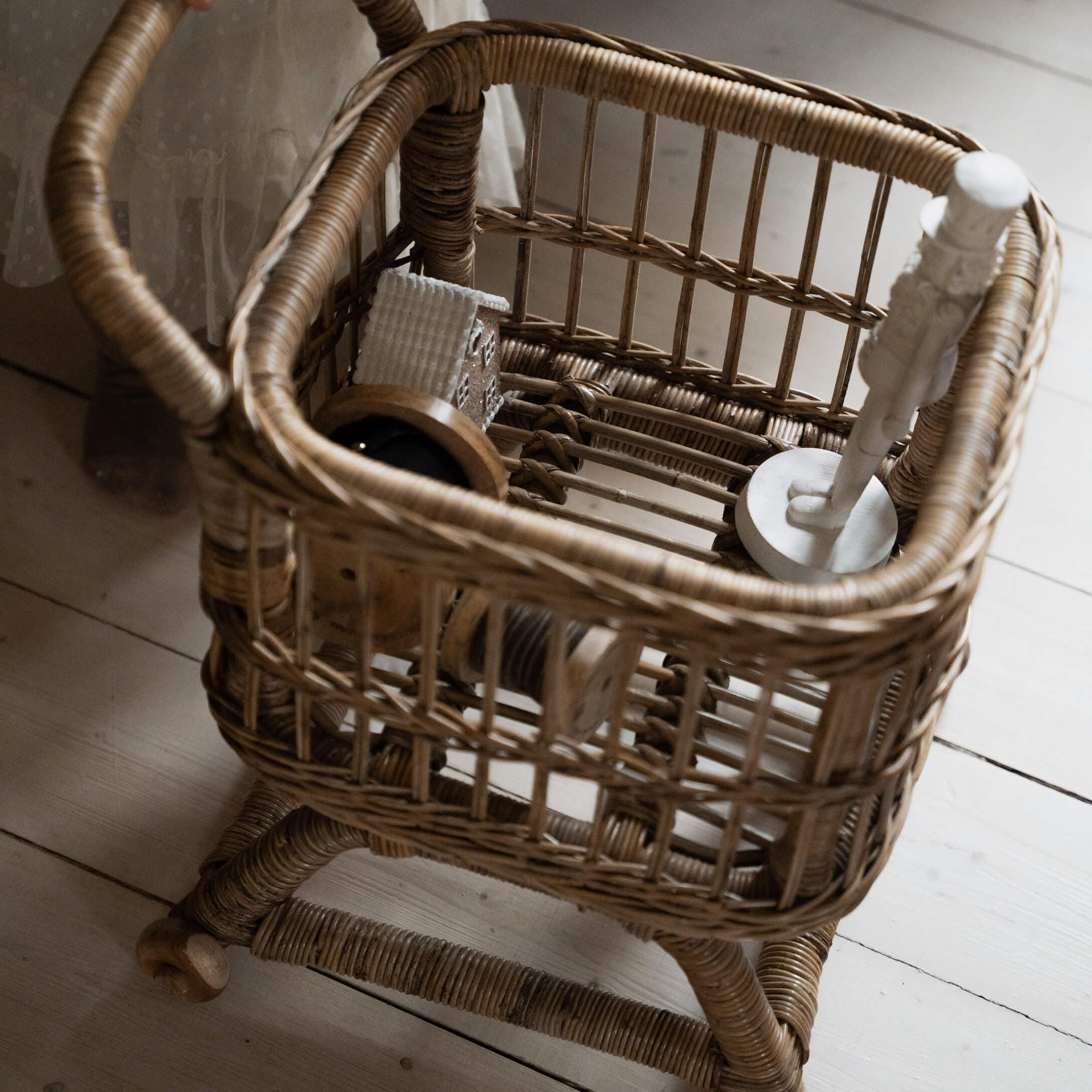 Cesta de ratán natural con asa y ruedas, elemento decorativo para interiores acogedores