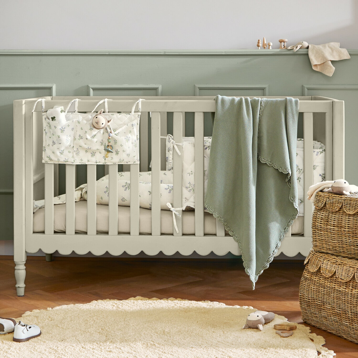 Cuna de bebé Leily Cuna infantil de madera beige con manta verde y ropa de cama floral en habitación infantil acogedora