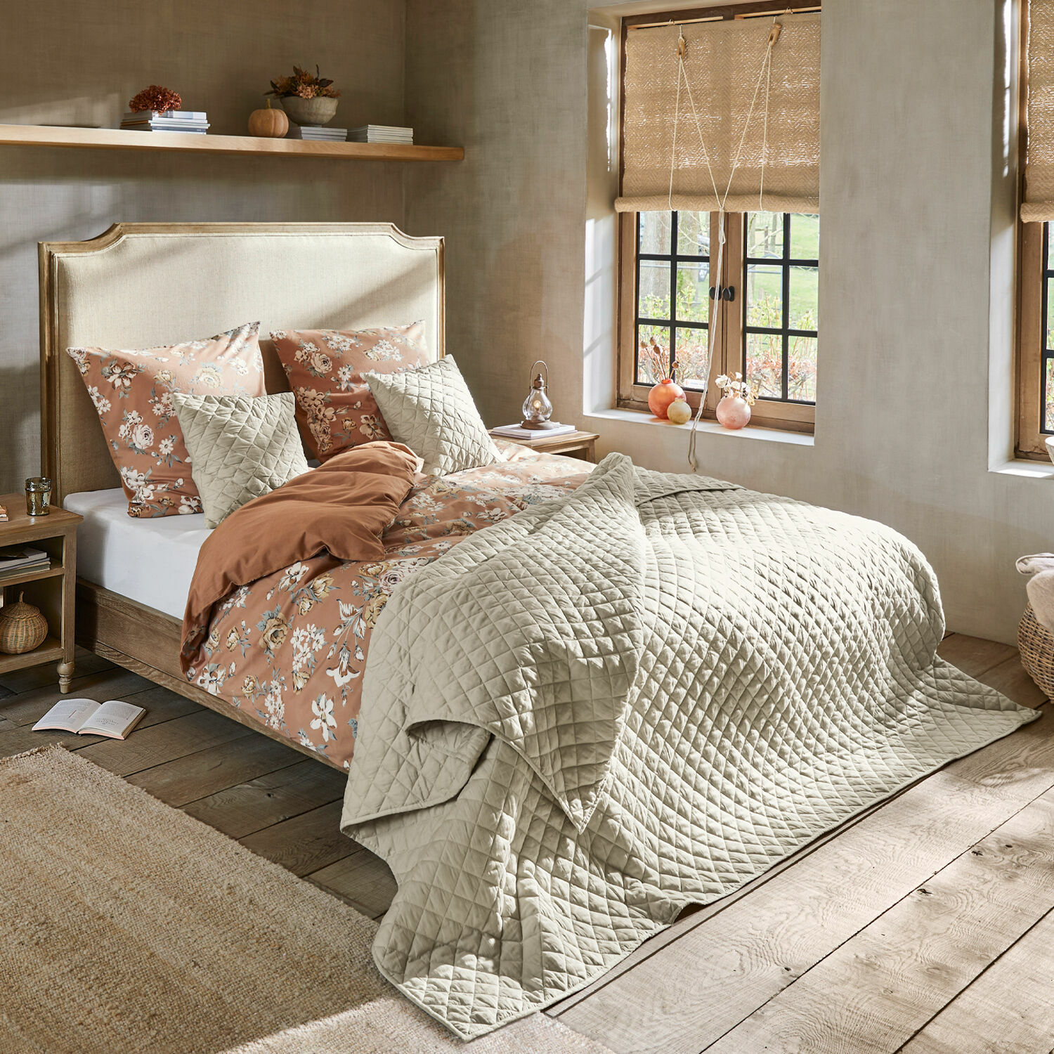 Cama Catham Dormitorio acogedor con cama con colcha acolchada beige y ropa de cama floral en tonos cálidos